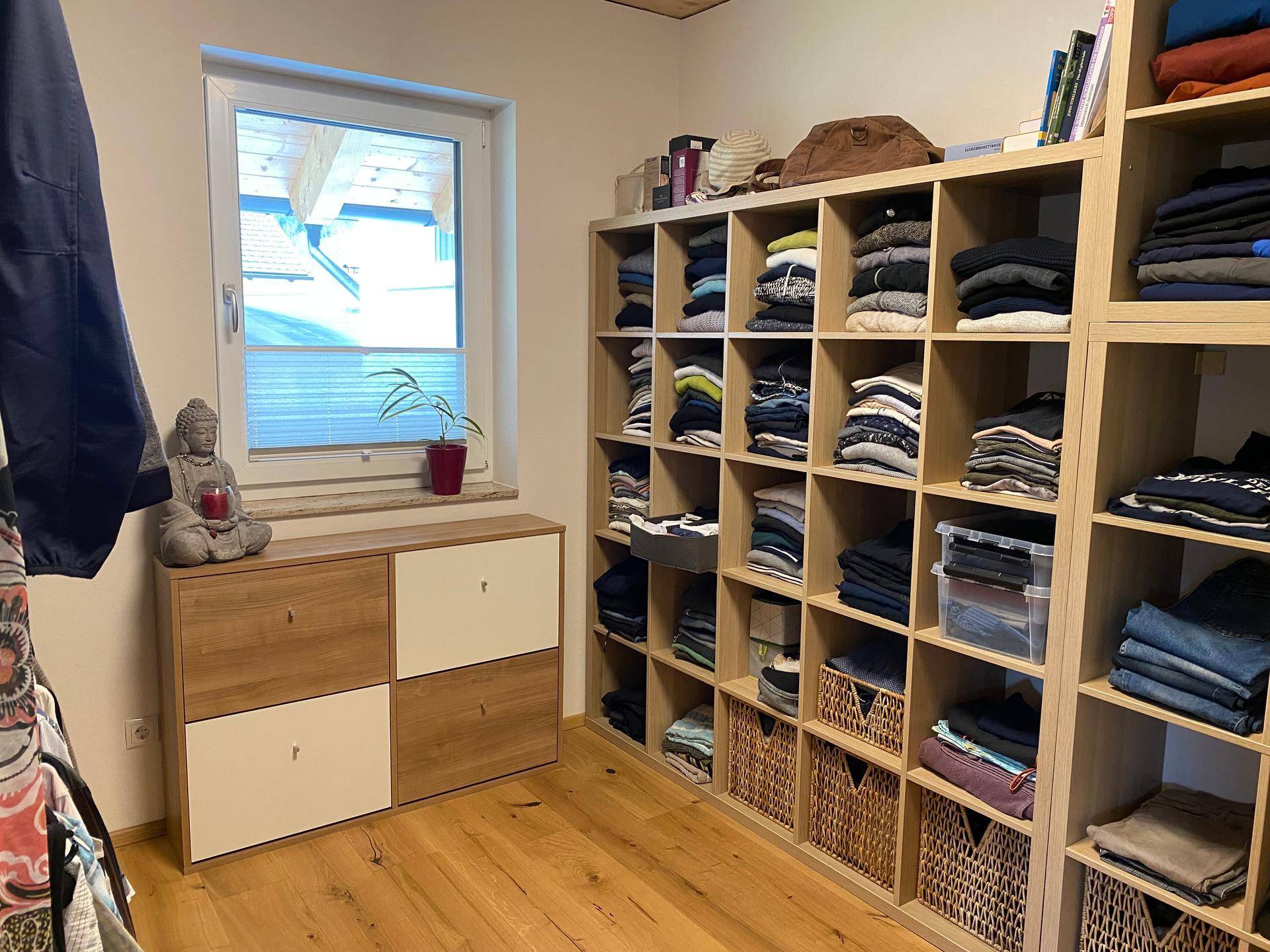 Begehbarer Kleiderschrank mit offenen Regalen, Stauraum und Fenster für Tageslicht.