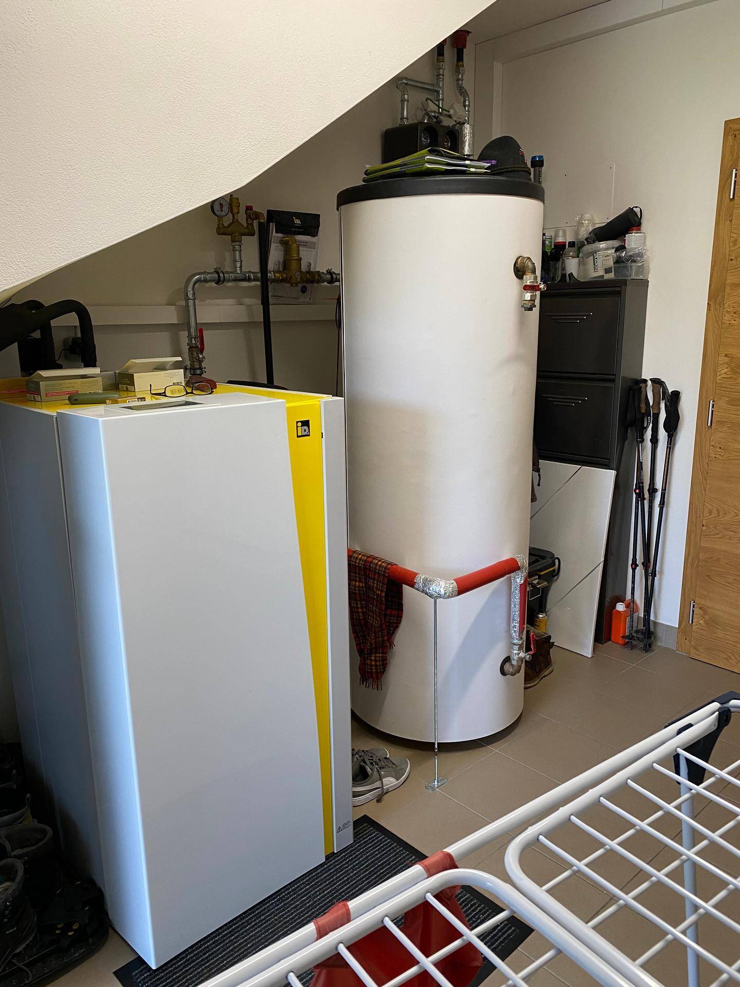 Heizungsraum mit modernem Heizkessel und Warmwasserspeicher für effiziente Energieversorgung.