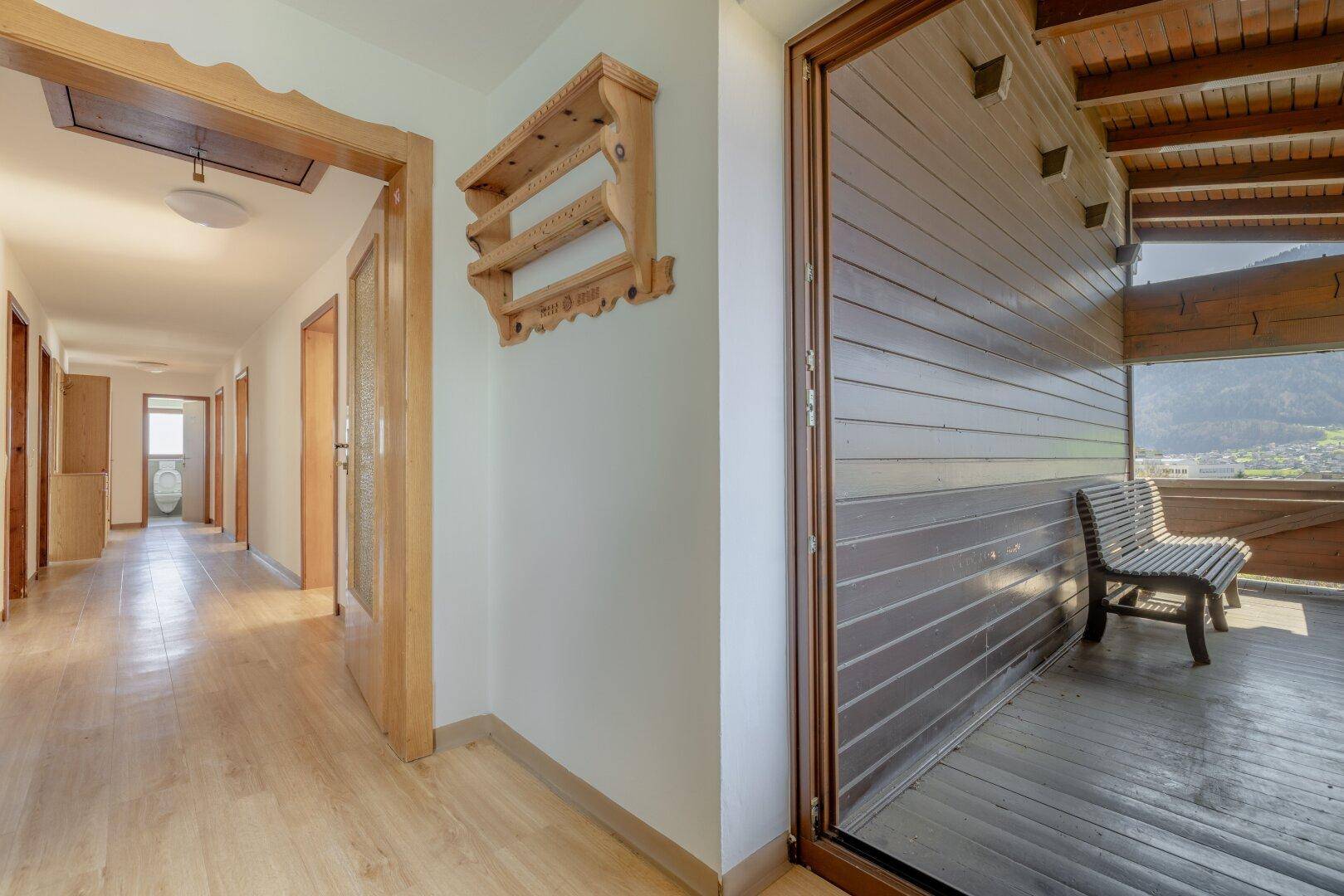Heller Flur mit Holzboden und Zugang zu einem Balkon mit Bergblick, der zum Entspannen einlädt.
