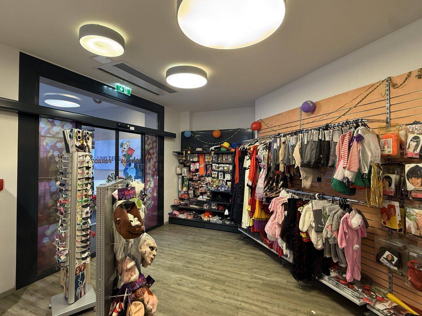 Innenansicht eines Ladens mit Kostümen und Accessoires, gut beleuchtet.