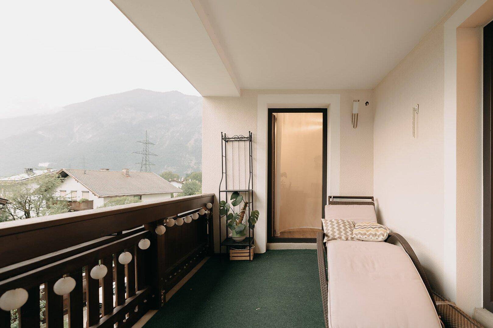 Balkon mit Liege und Pflanzen, bietet einen entspannenden Bereich mit Bergaussicht.