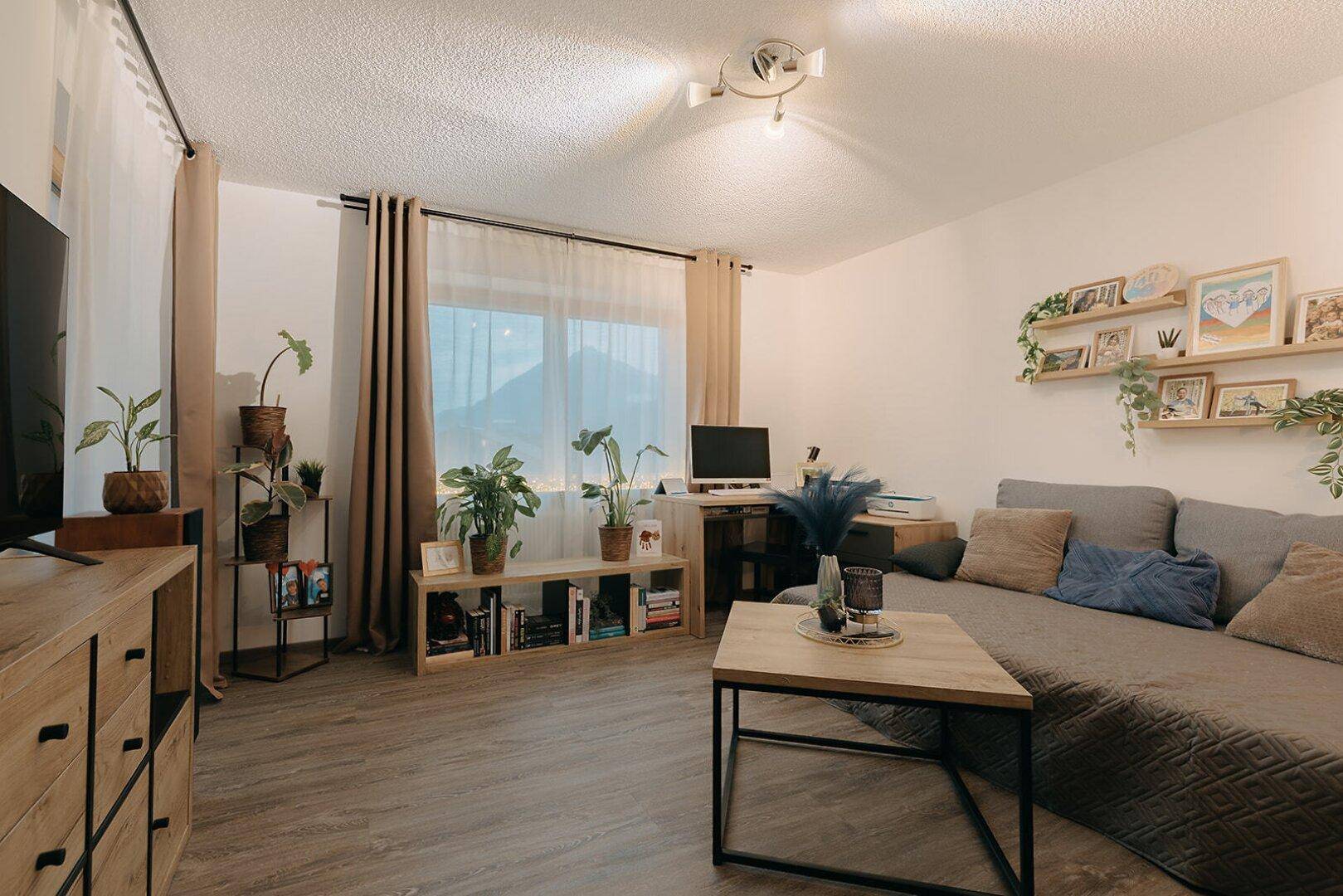 Wohnzimmer mit großem Ecksofa, Couchtisch und Regalen mit Dekoration, hell und einladend.