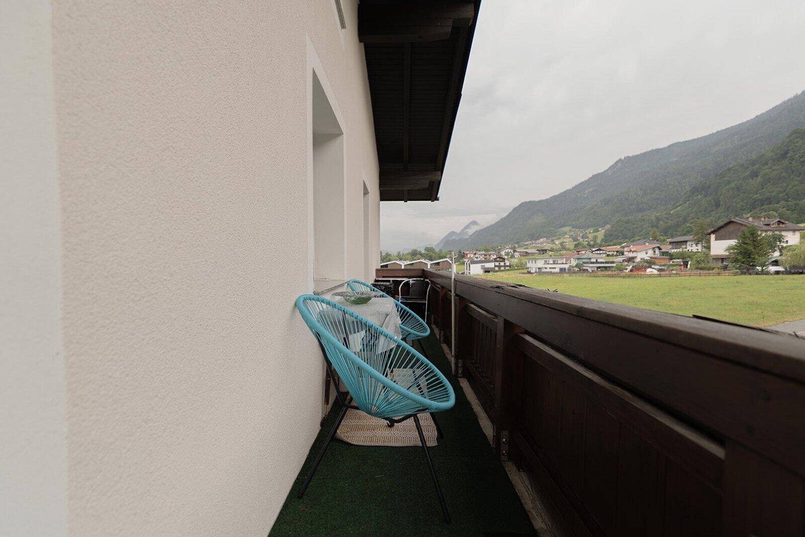 Kleiner Balkon mit Sitzgelegenheiten und malerischem Blick auf die umliegenden Berge.