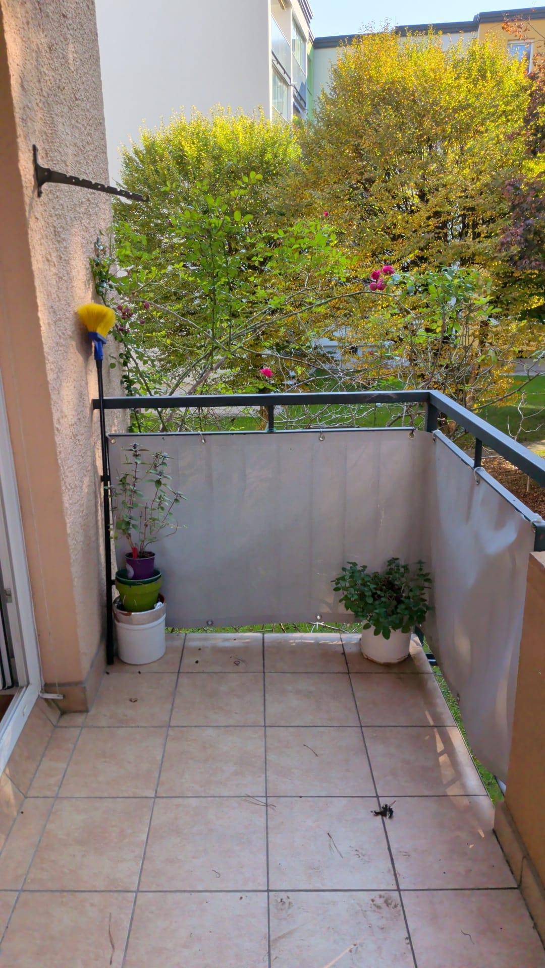 Kleiner Balkon mit Pflanzen und Fliesenboden, bietet einen ruhigen Außenbereich.