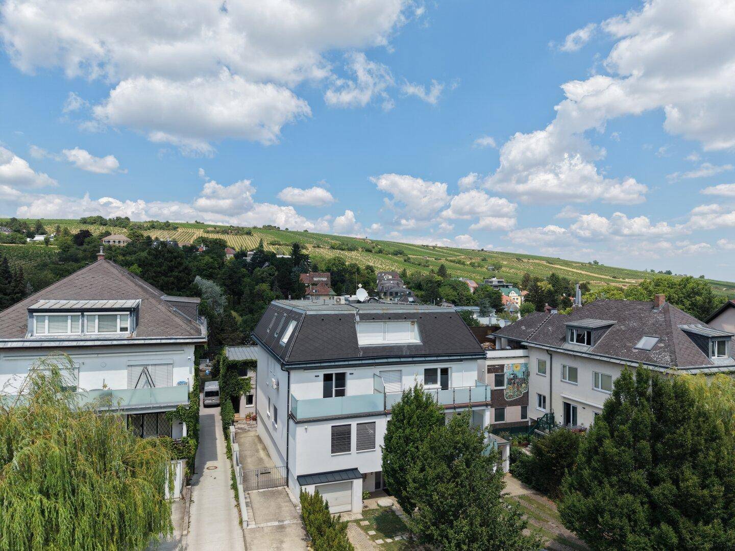 Luftaufnahme eines modernen Wohnhauses mit Balkonen und Blick auf die umliegenden Weinberge.