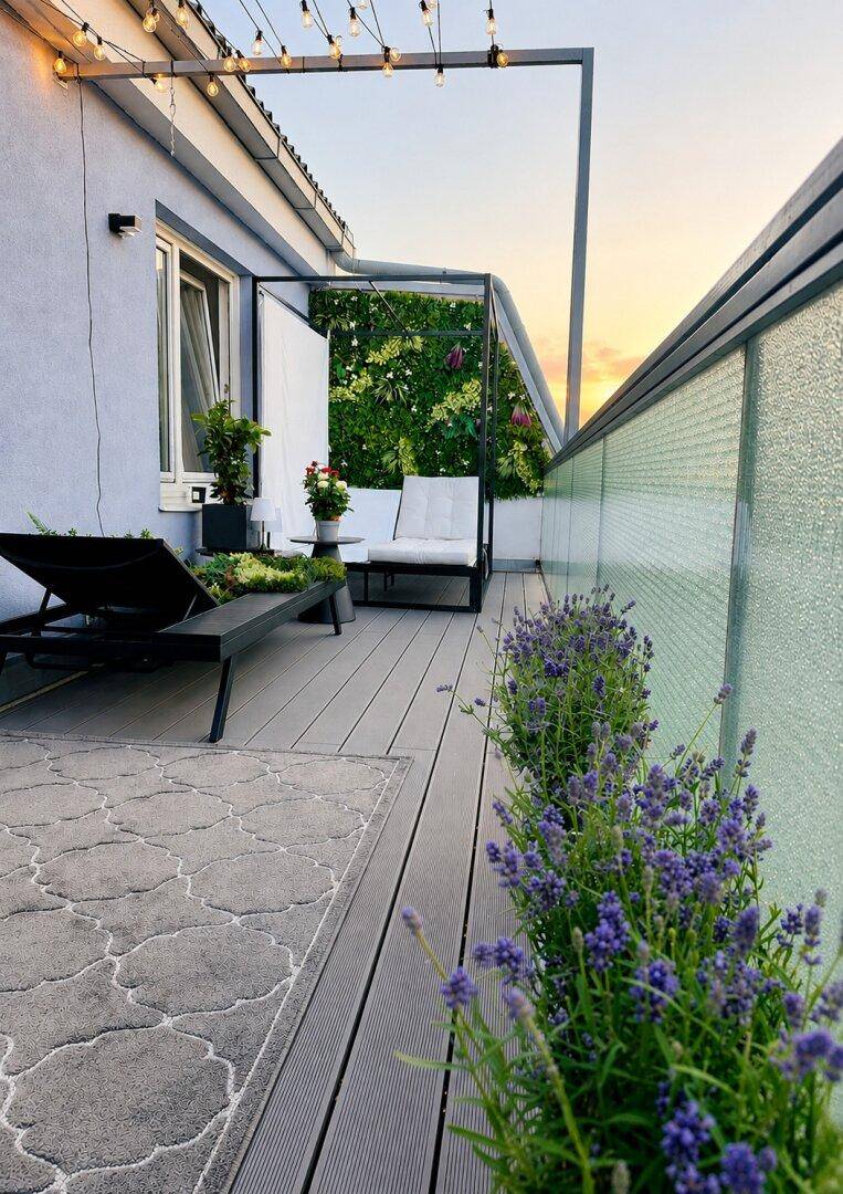 Stimmungsvolle Terrasse bei Sonnenuntergang mit Lavendelpflanzen, Liegestuhl und Lichterkette für gemütliche Abende.