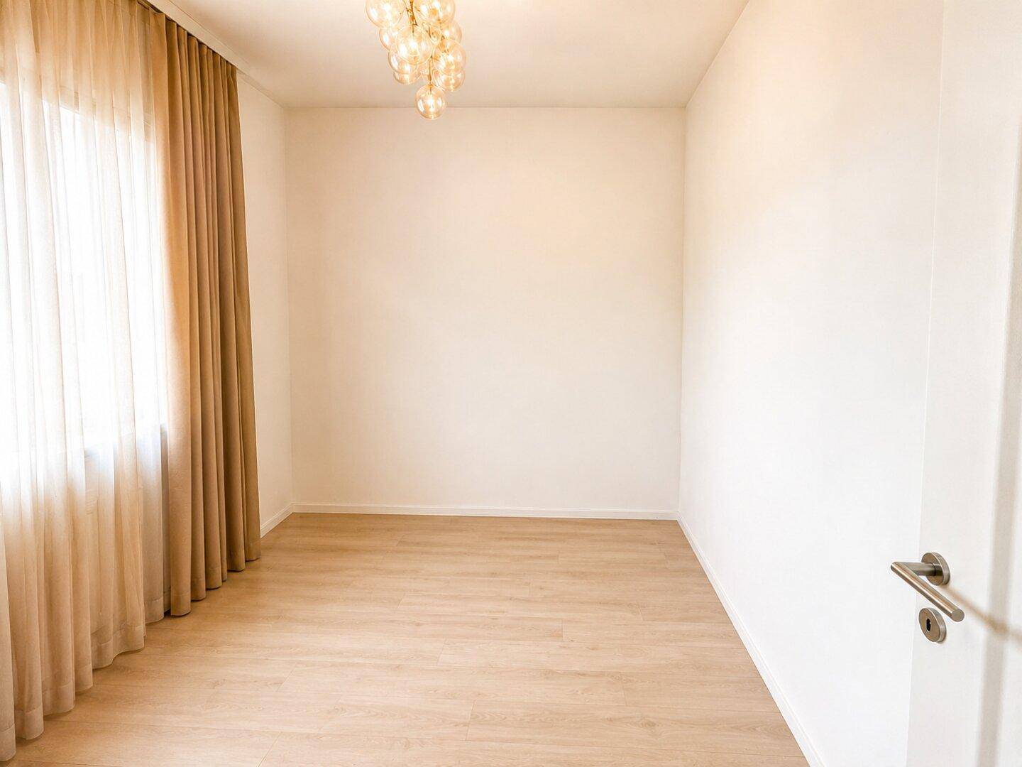 Leerer Raum mit hellem Laminatboden, weißen Wänden und großen Fenstern, bereit zur individuellen Gestaltung.