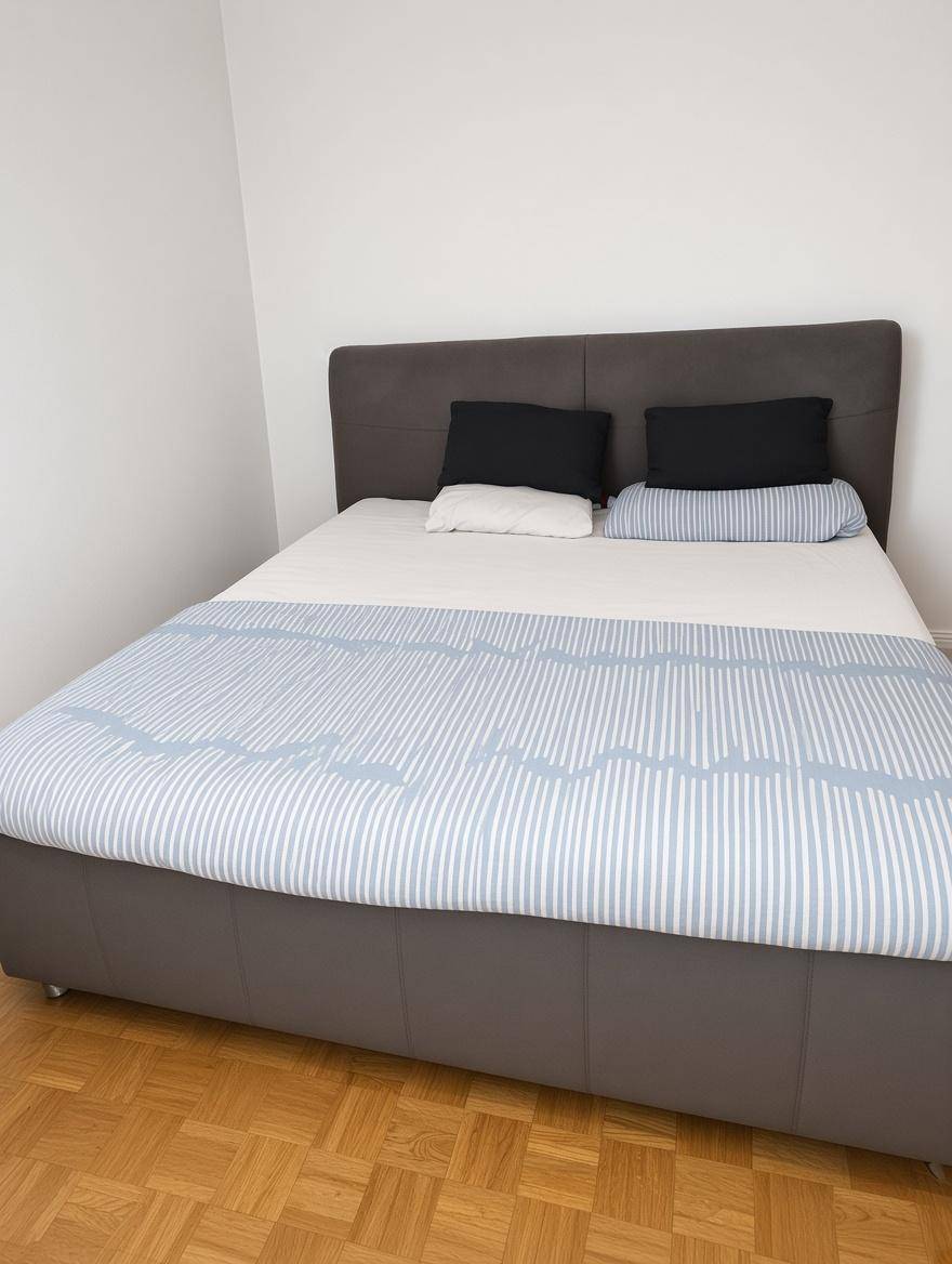 Gemütliches Schlafzimmer mit großem Bett und Parkettboden.