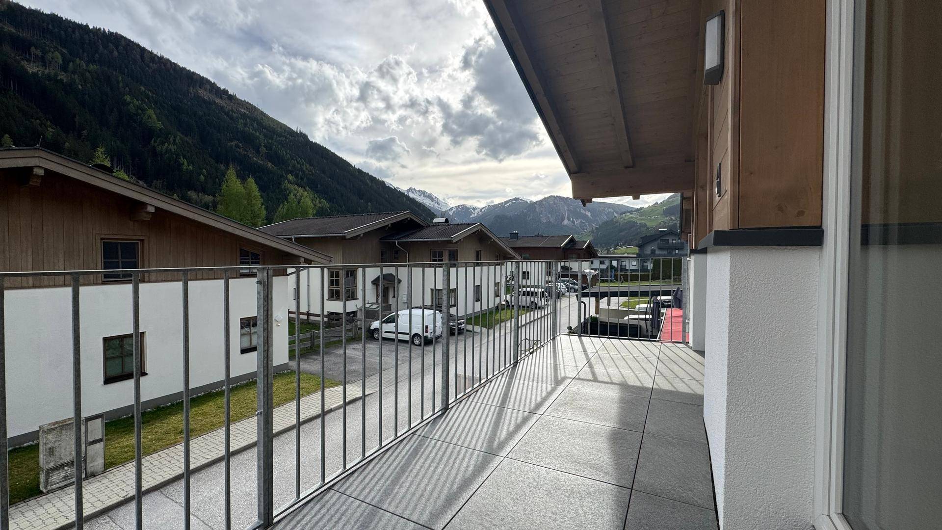 Balkon mit Fliesenboden und Metallgeländer, bietet einen weiten Blick auf die Berge und die Umgebung.