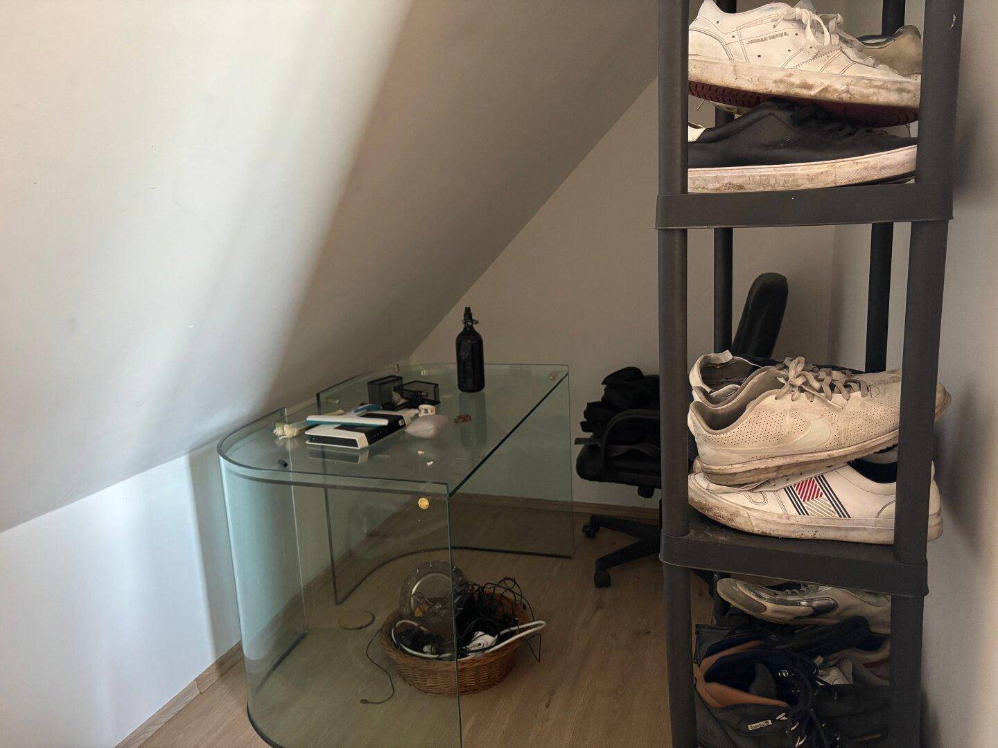 Kleines Büro im Dachgeschoss mit Glas-Schreibtisch und Stauraum.