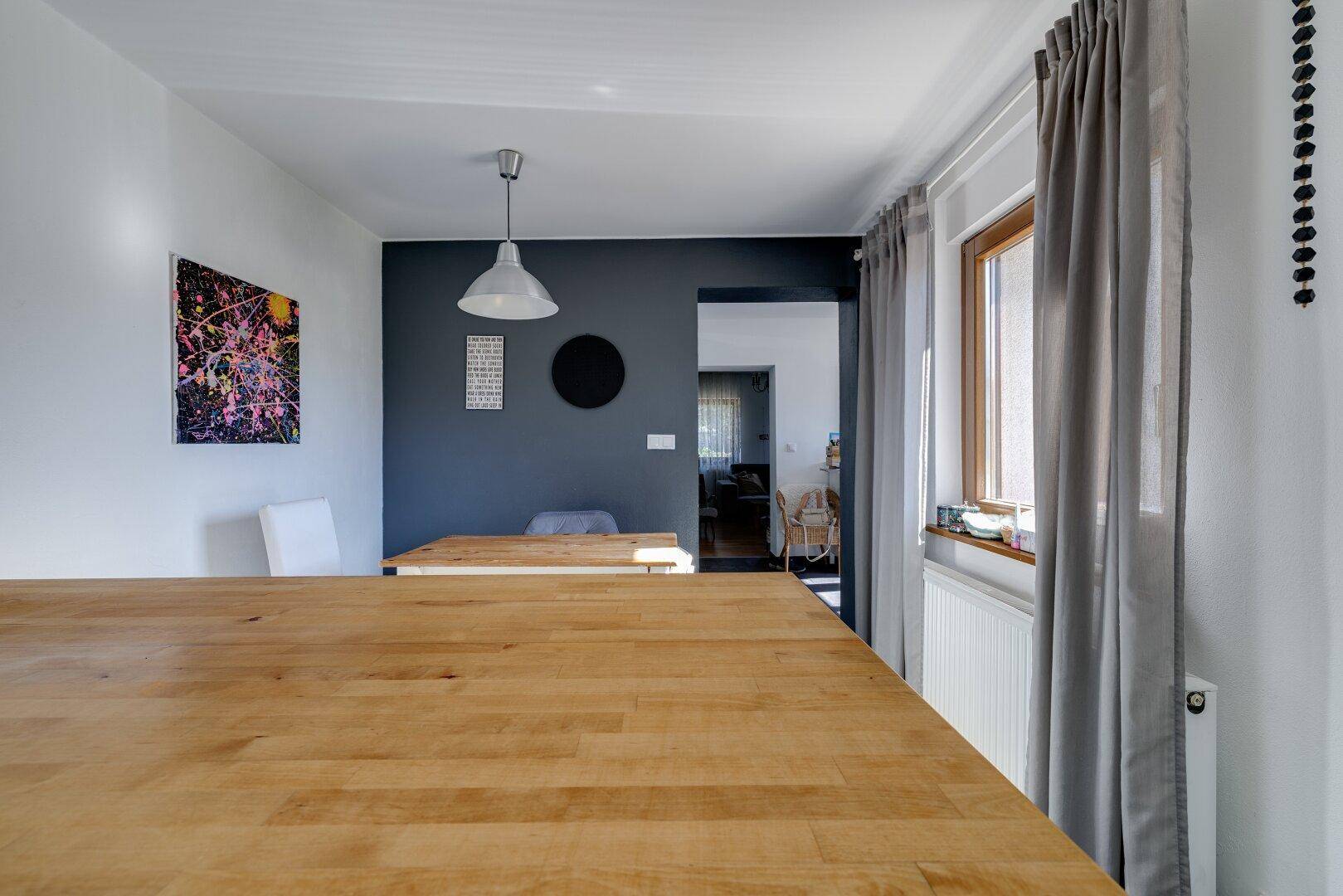 Geräumige Küche mit großer Holz-Arbeitsfläche und Blick in den angrenzenden Wohnbereich.