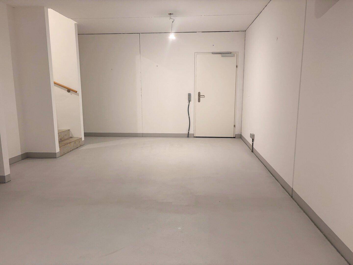 Großer, heller Kellerbereich mit Zugangstür und Treppe, vielseitig nutzbar.