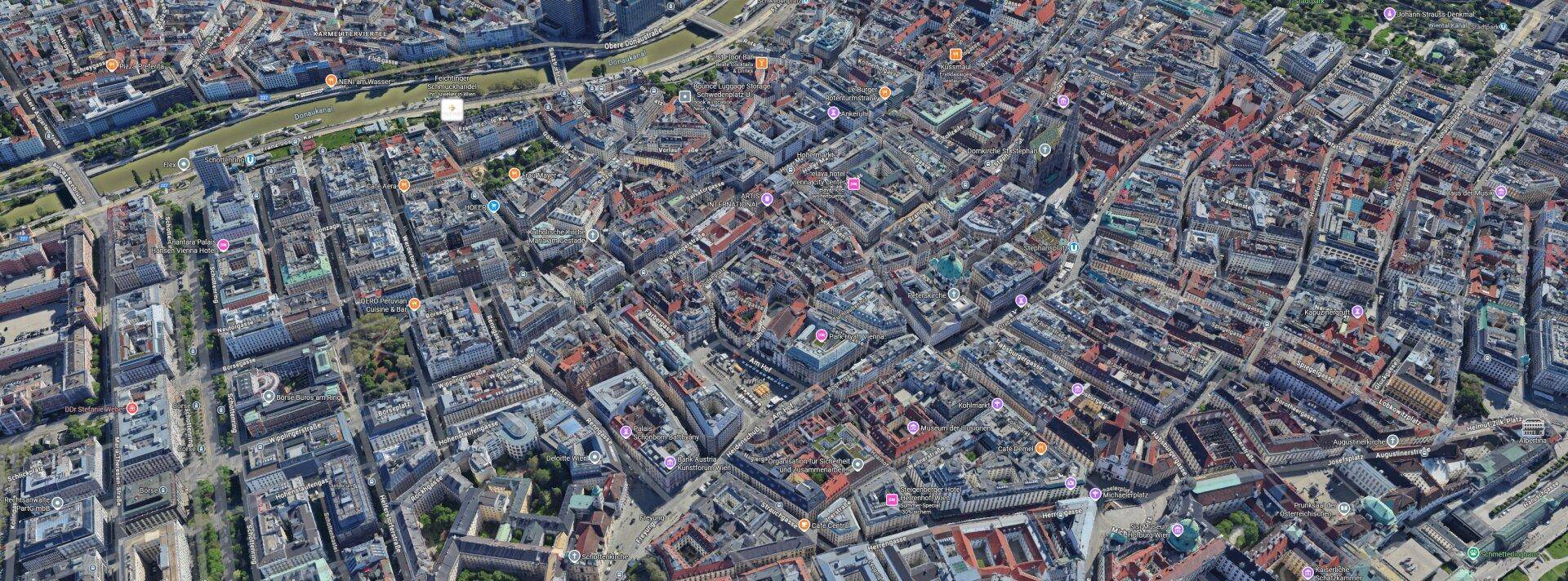 Luftaufnahme einer dicht bebauten Stadtlandschaft mit zahlreichen Gebäuden und Straßen.