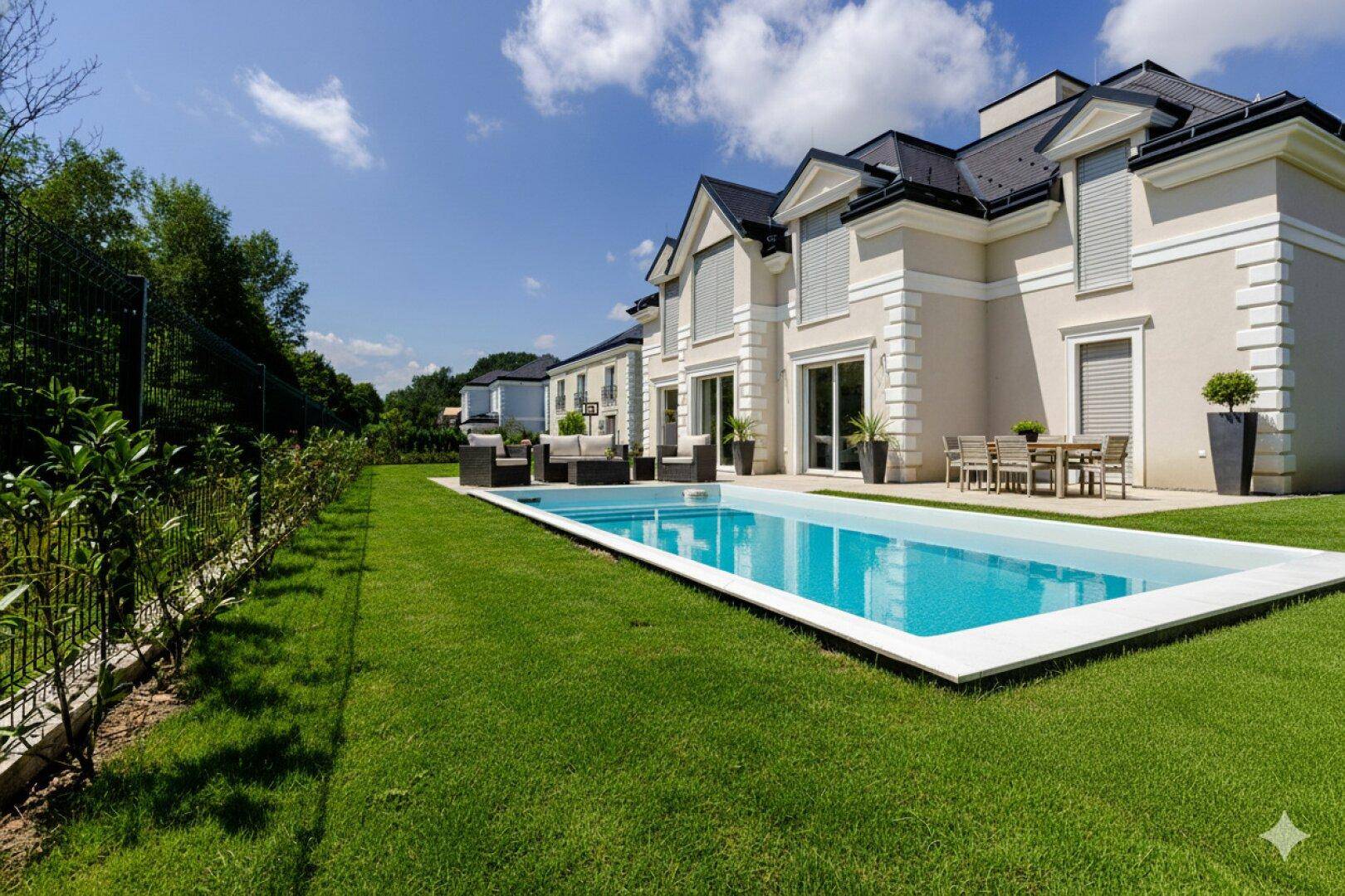Fertiggestellter Neubau mit großem Pool, gepflegtem Rasen und möblierter Terrasse.