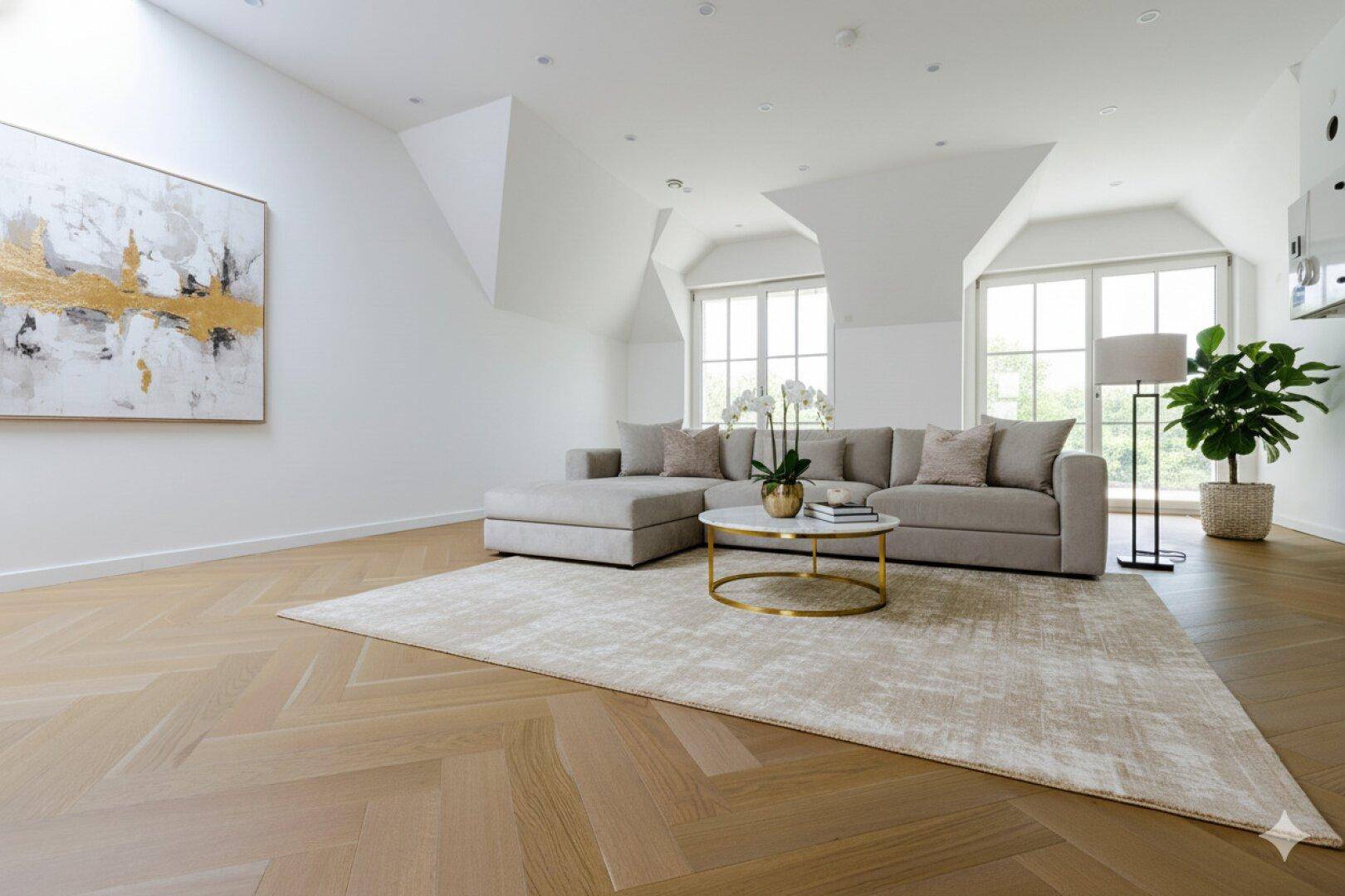 Gemütliches Wohnzimmer mit Dachschrägen, großen Fenstern und modernem Sofa.