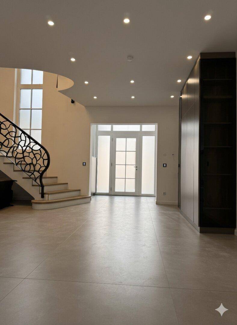 Heller Eingangsbereich mit eleganter Treppe, integrierten Schränken und viel Tageslicht.