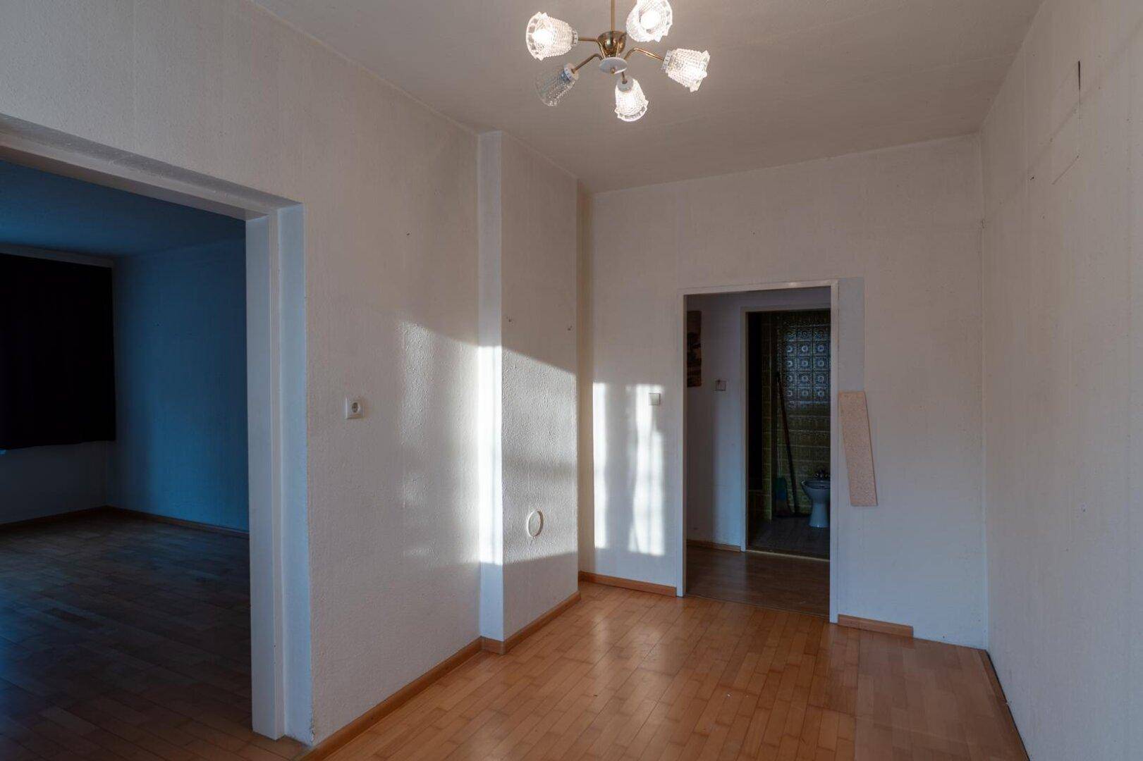 Heller Flur mit Laminatboden und mehreren Türöffnungen zu angrenzenden Räumen.
