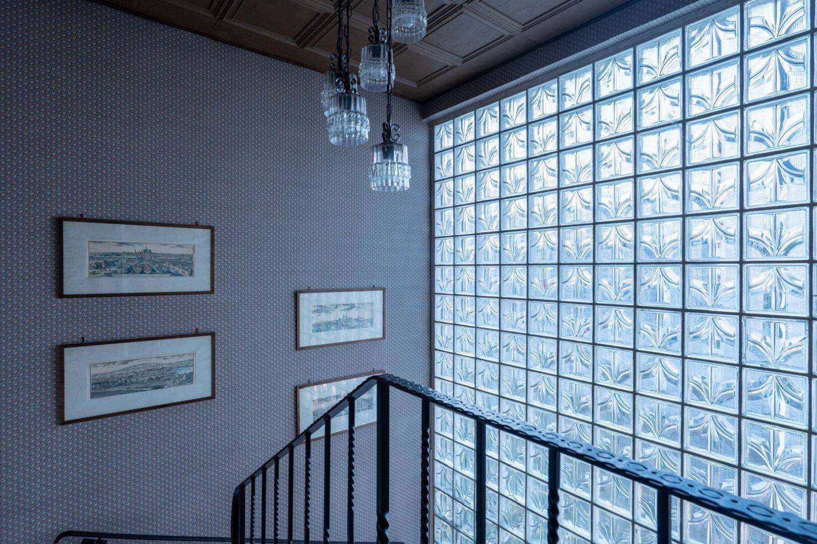 Treppenhaus mit beeindruckender Glasbausteinwand und eleganter Deckenleuchte, sorgt für Helligkeit.