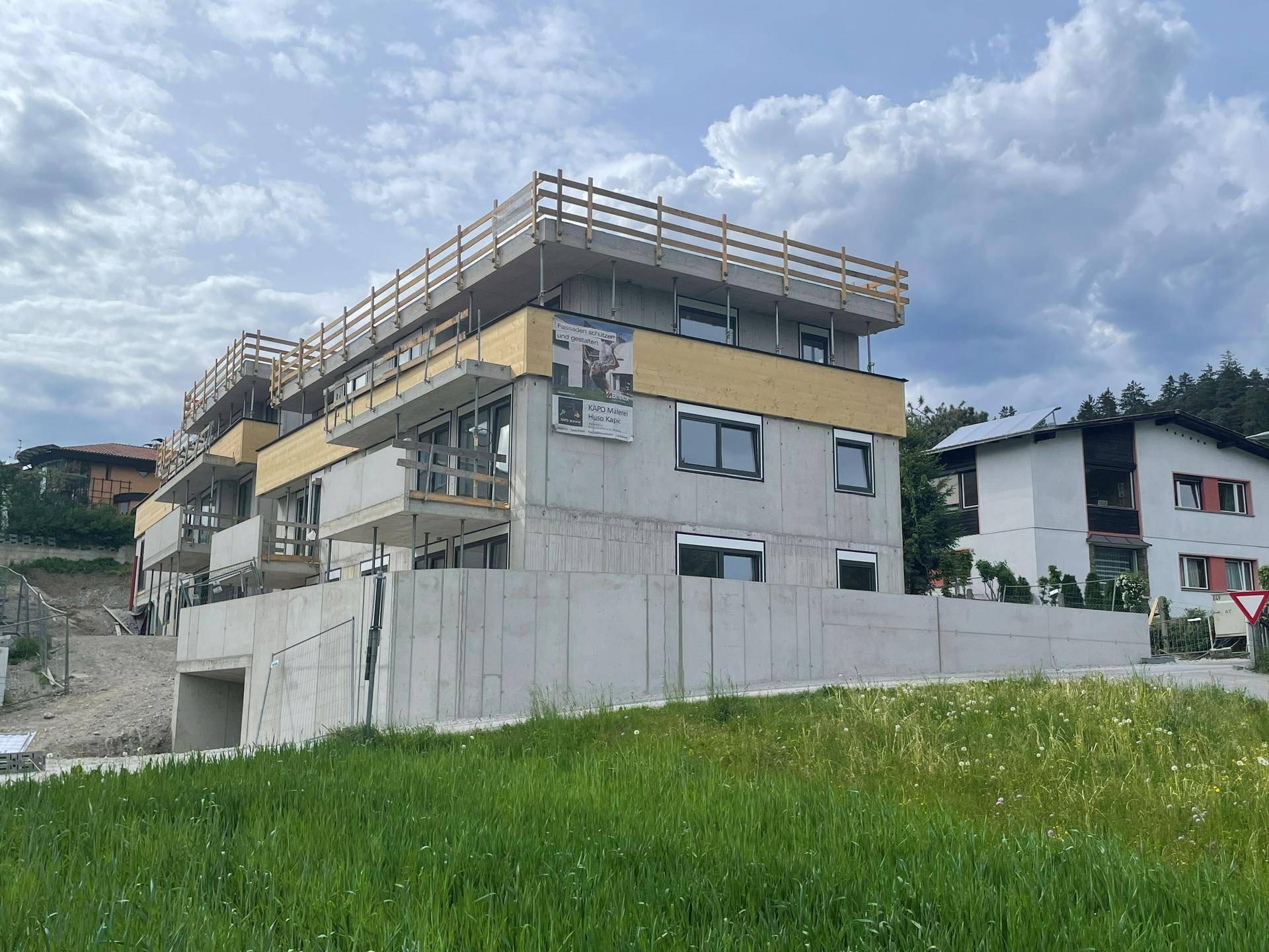 Neubau einer modernen Wohnanlage in der Bauphase, umgeben von Natur und Grünflächen.