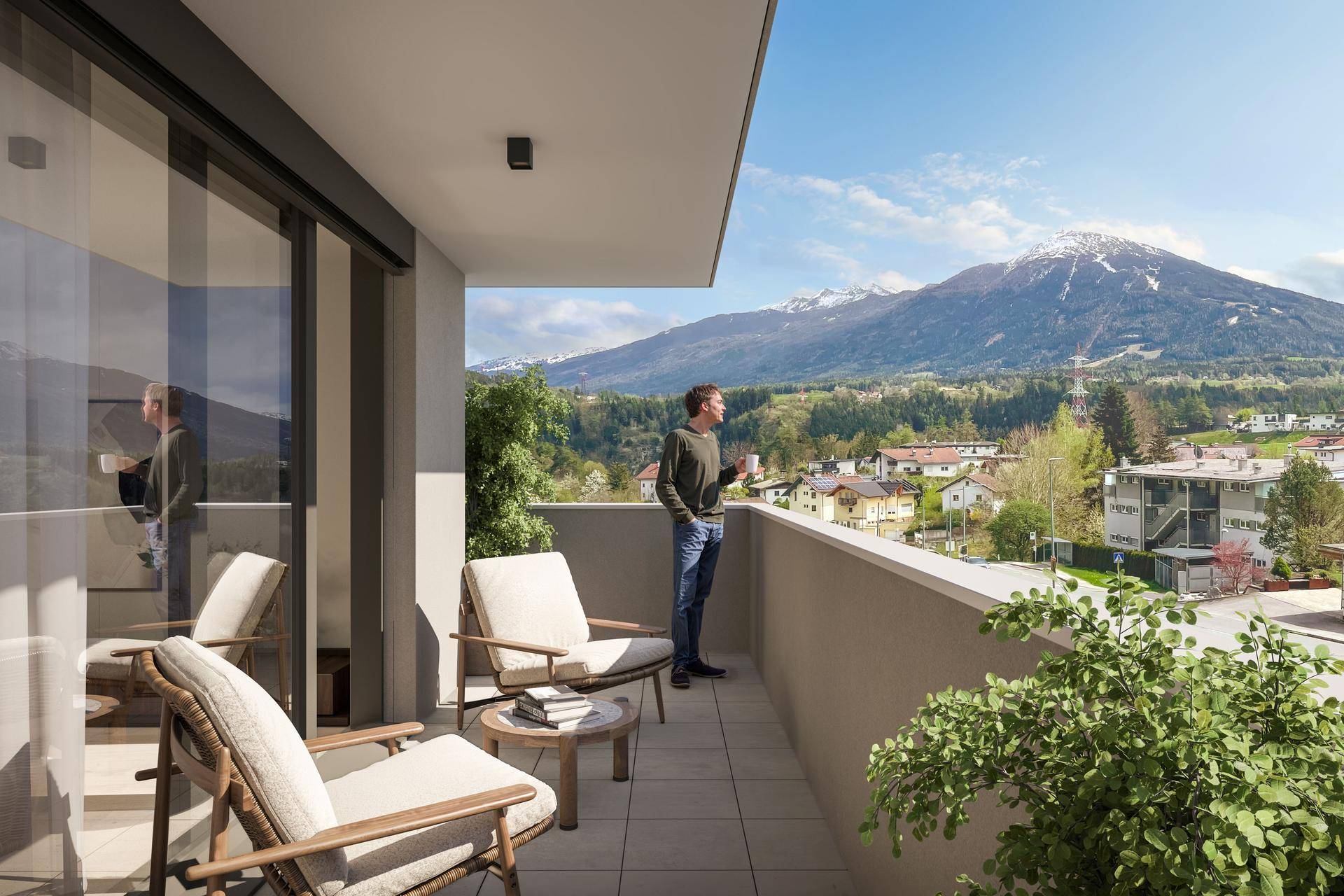 Balkon mit Sitzgelegenheiten und weitem Blick auf die umliegende Berglandschaft.