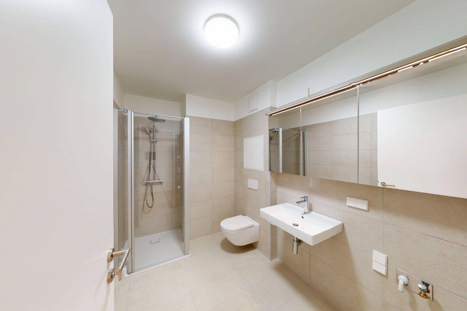 Modernes Badezimmer mit begehbarer Dusche, Wand-WC und großem Spiegelschrank.