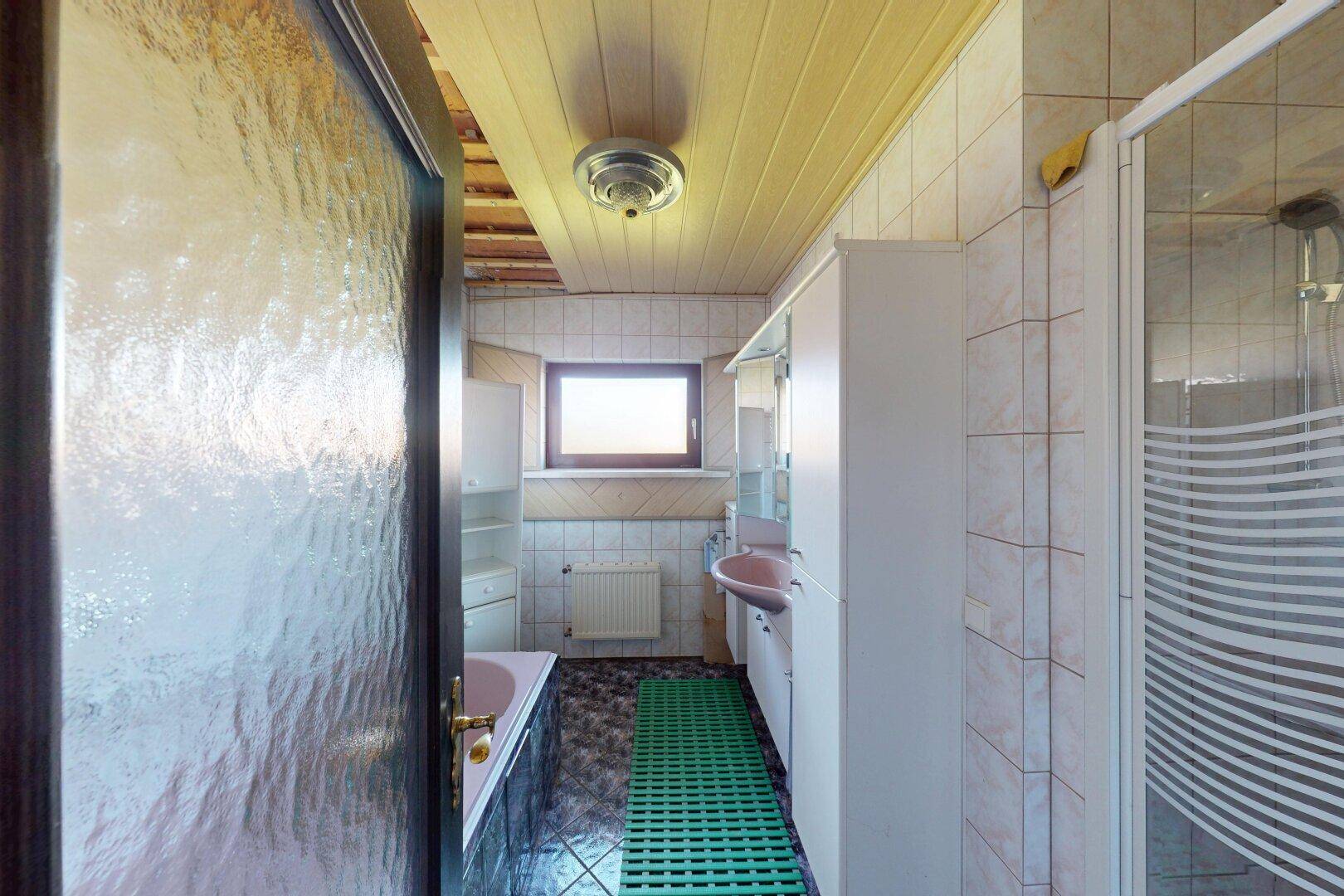 Badezimmer mit rosa Waschbecken, Badewanne und Duschkabine.