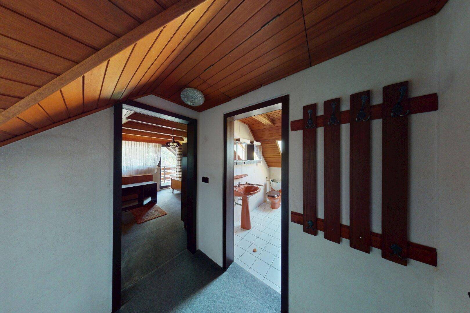Flur im Dachgeschoss mit Zugang zu Bad und weiterem Zimmer.