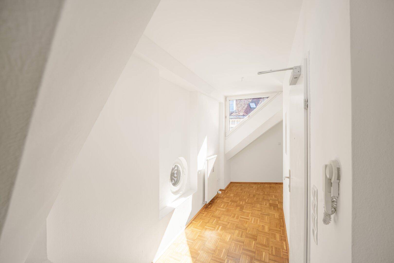Eingangsbereich im Dachgeschoss mit Parkettboden und viel Tageslicht.