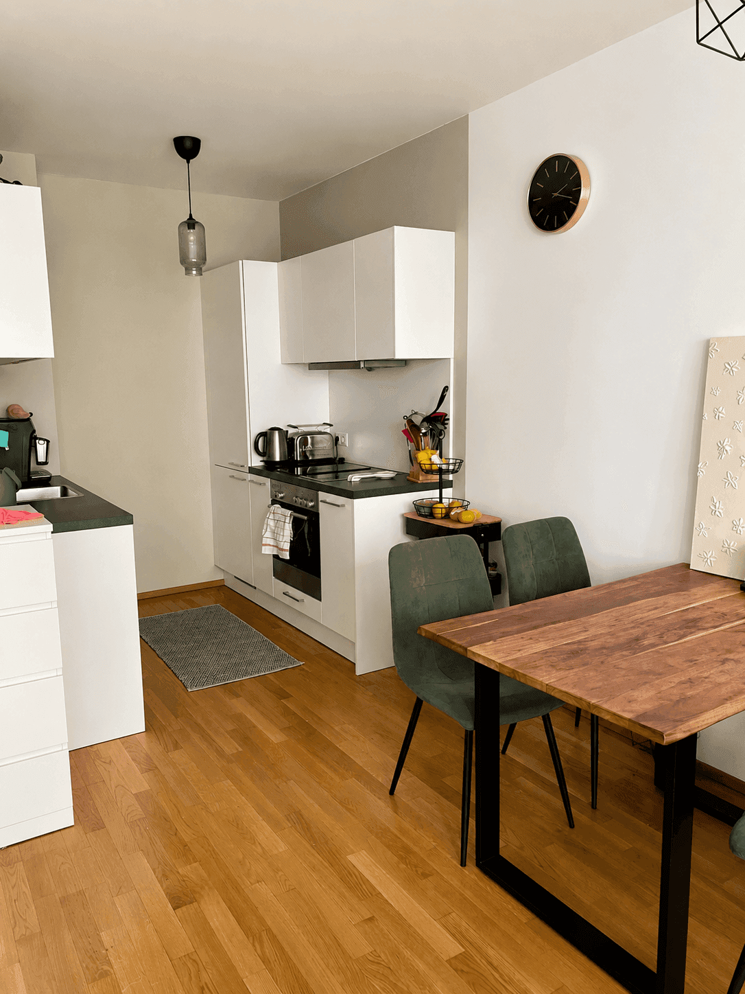 Helle Küche mit Essbereich, modernen Geräten und Holztisch für gemütliche Mahlzeiten.