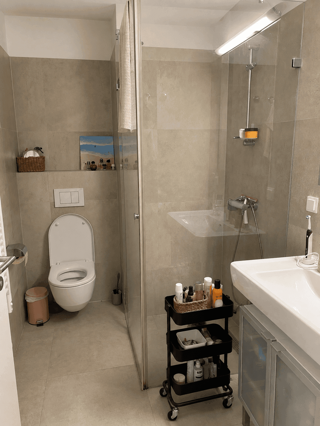 Modernes Badezimmer mit begehbarer Dusche, Wand-WC und großformatigen Fliesen.