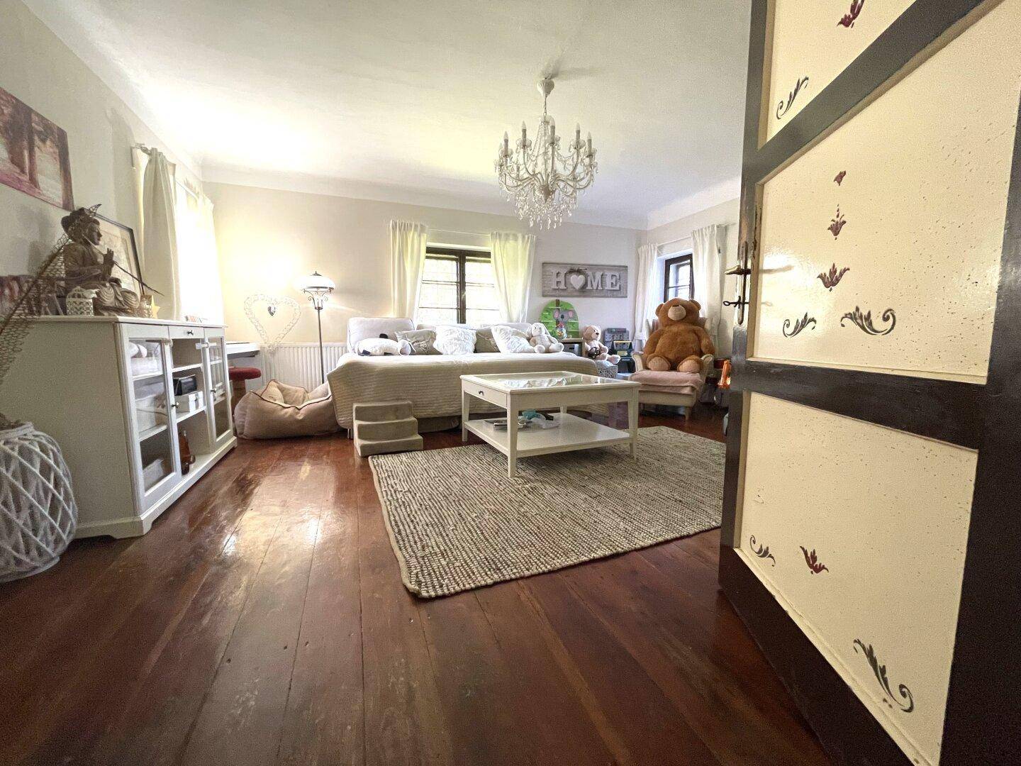 Helles Wohnzimmer mit Holzboden, weißer Einrichtung und dekorativen Elementen.
