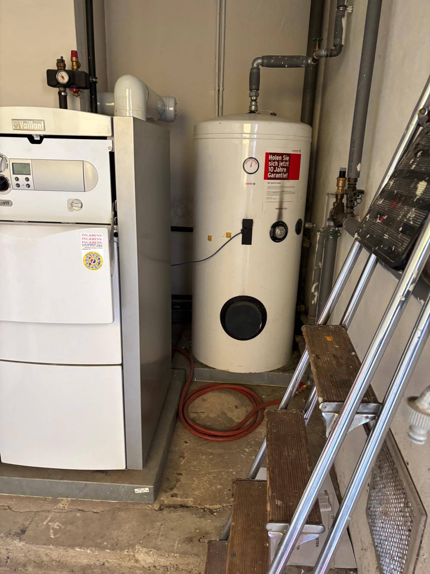 Technikraum mit Vaillant Heizkessel, Warmwasserspeicher und einer Leiter im Vordergrund.