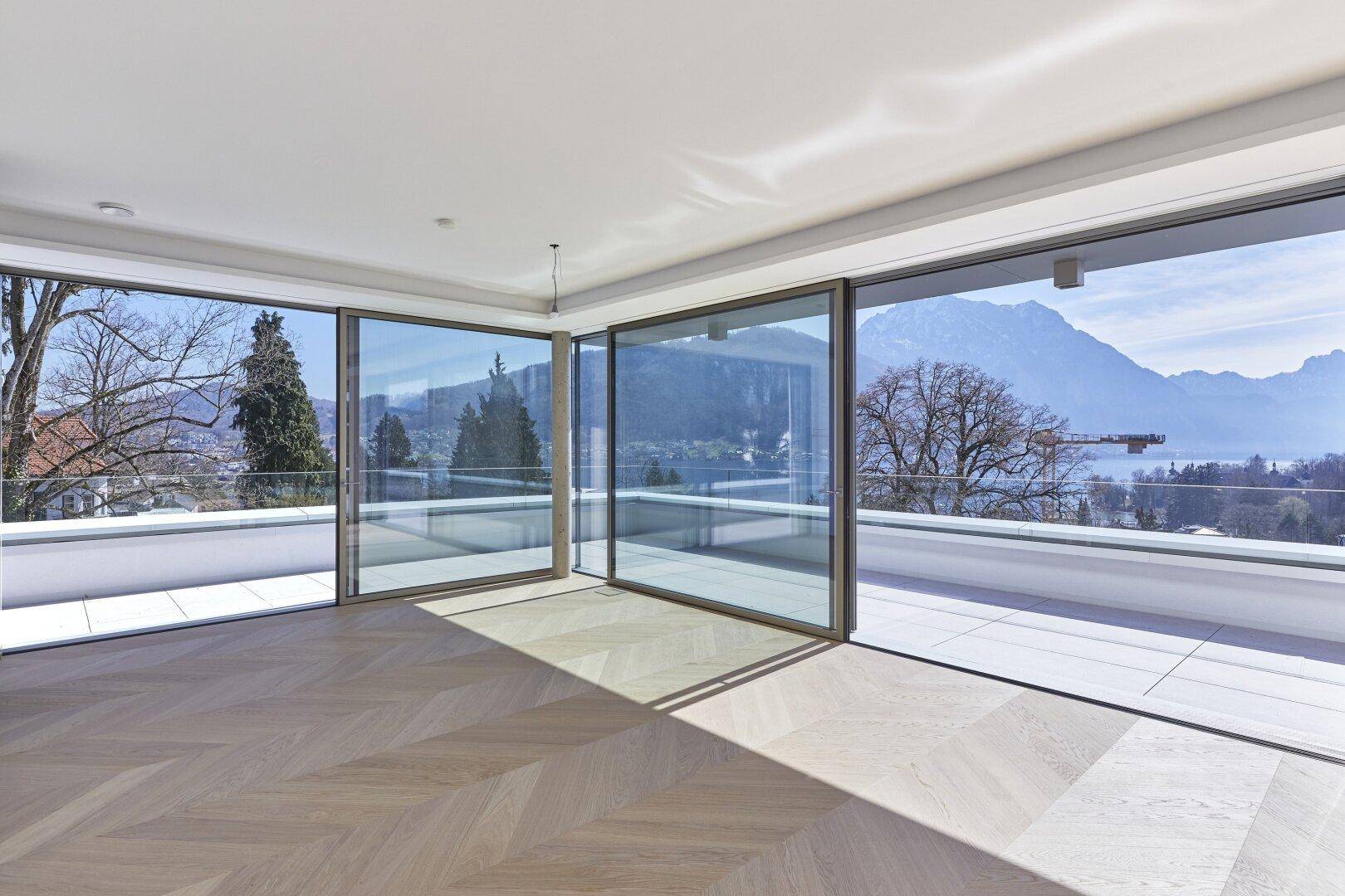 Lichtdurchfluteter Wohnraum mit elegantem Fischgrätparkett und Zugang zur großen Terrasse.