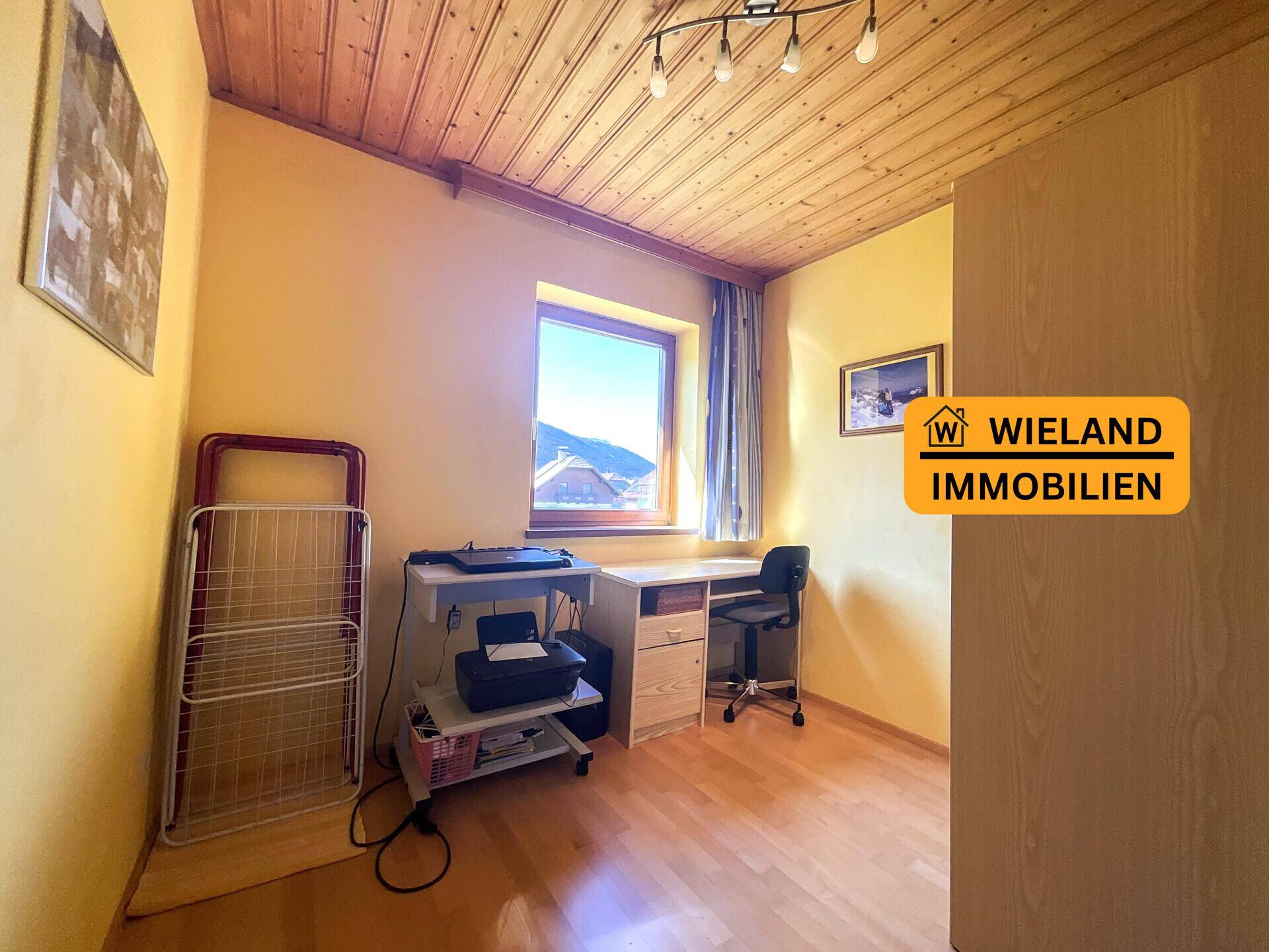 Helles Arbeitszimmer mit Holzboden, gelben Wänden und Holzdecke, ideal für Home-Office.