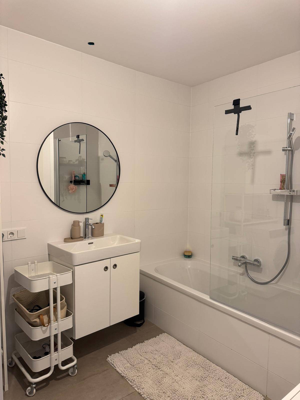 Helles Badezimmer mit Badewanne, Duschabtrennung und modernem Waschtisch.