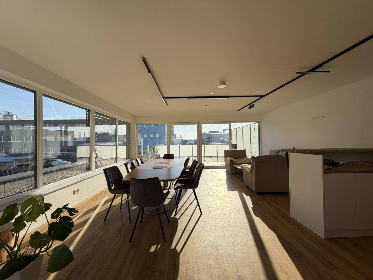 Offener Wohn- und Essbereich mit viel Tageslicht, Holzboden und Zugang zur Terrasse.