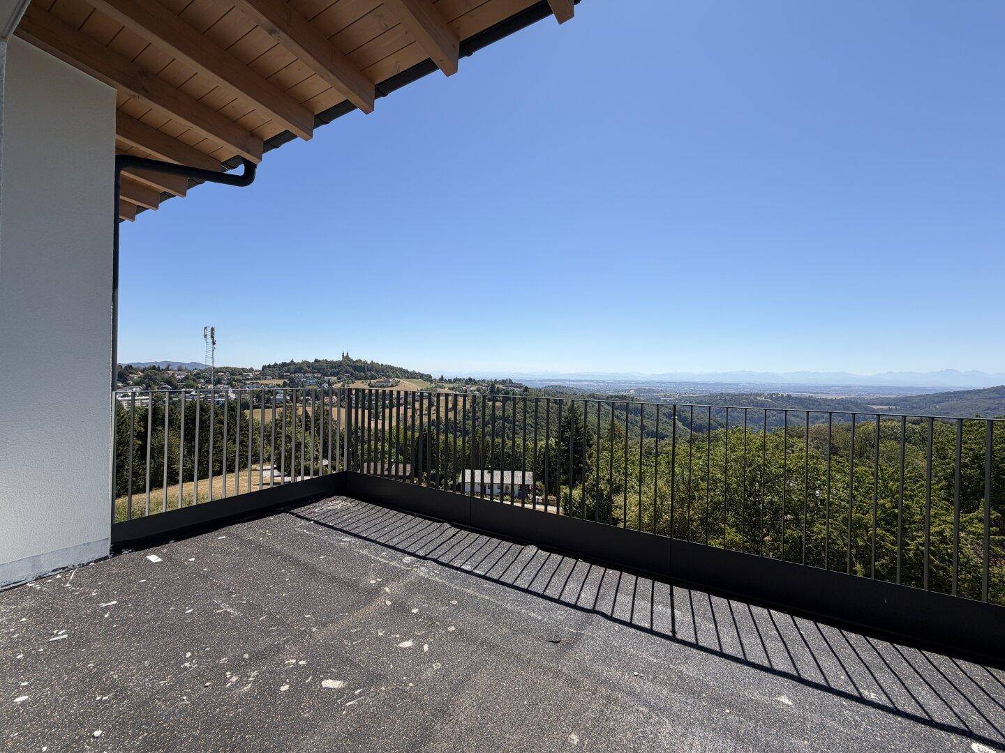 Geräumiger Balkon mit Metallgeländer und weitem Blick über die hügelige Landschaft.