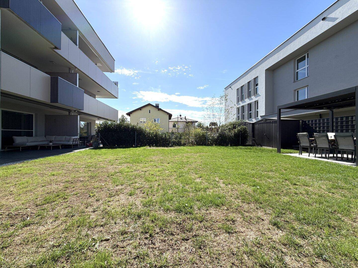 Großer Gemeinschaftsgarten zwischen modernen Wohngebäuden, ideal für Erholung im Freien.