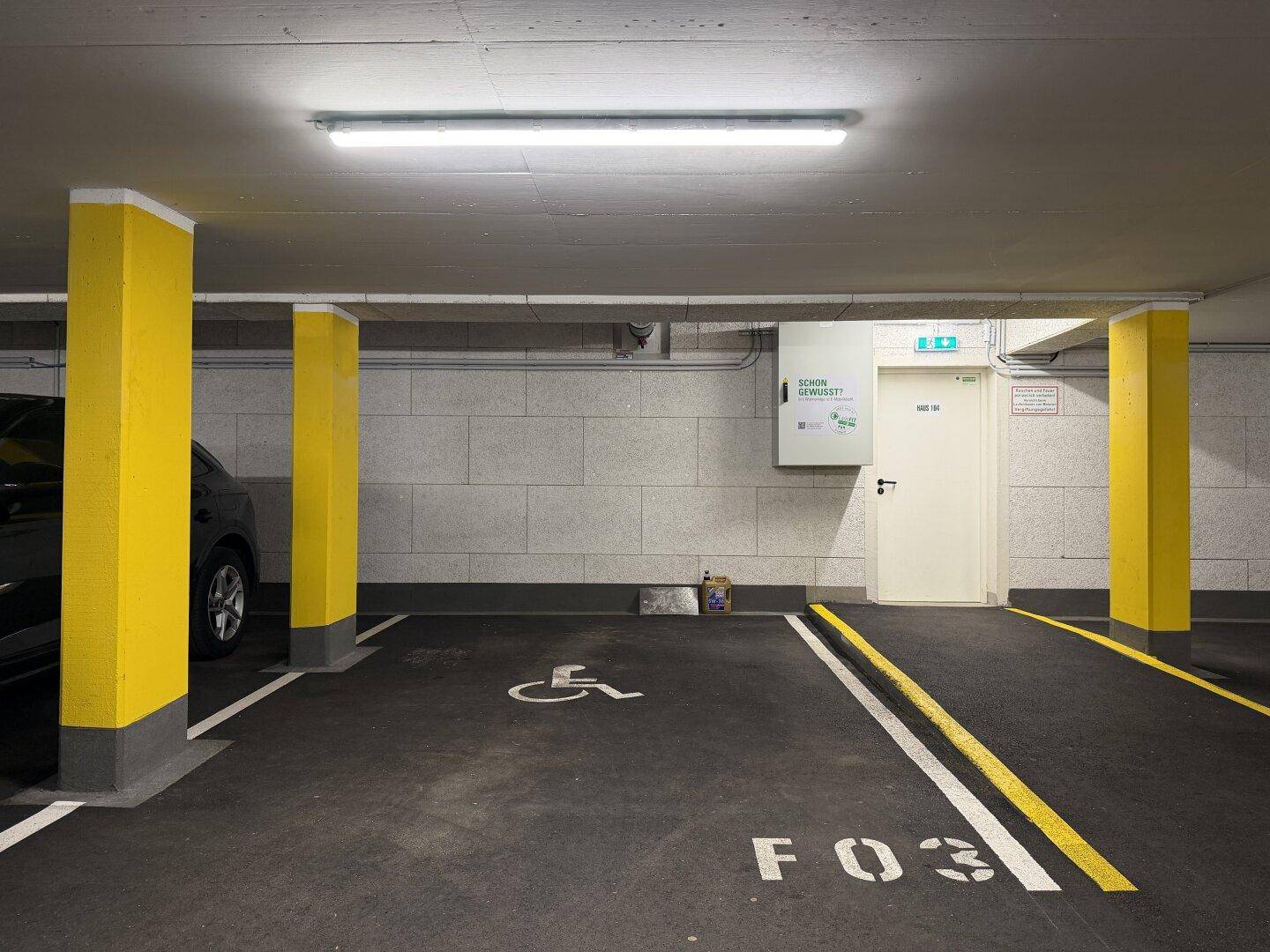 Tiefgarage mit markierten Parkplätzen, inklusive barrierefreiem Stellplatz.