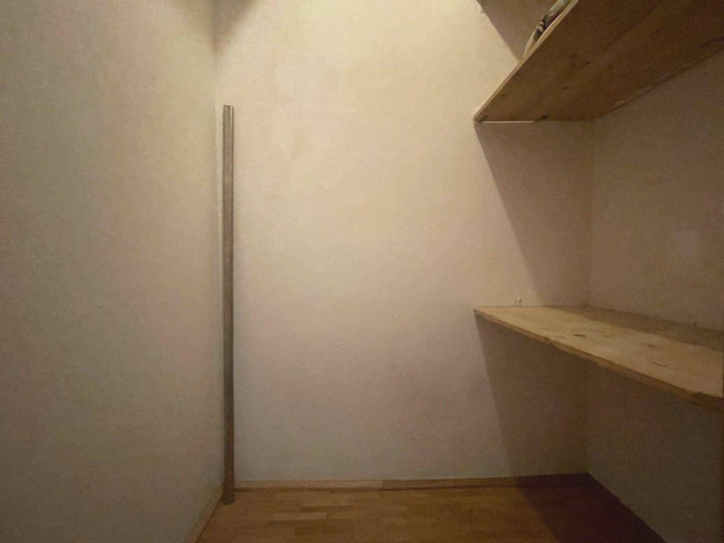 Praktischer Abstellraum mit Holzregalen bietet zusätzlichen Stauraum für Haushaltsgegenstände.