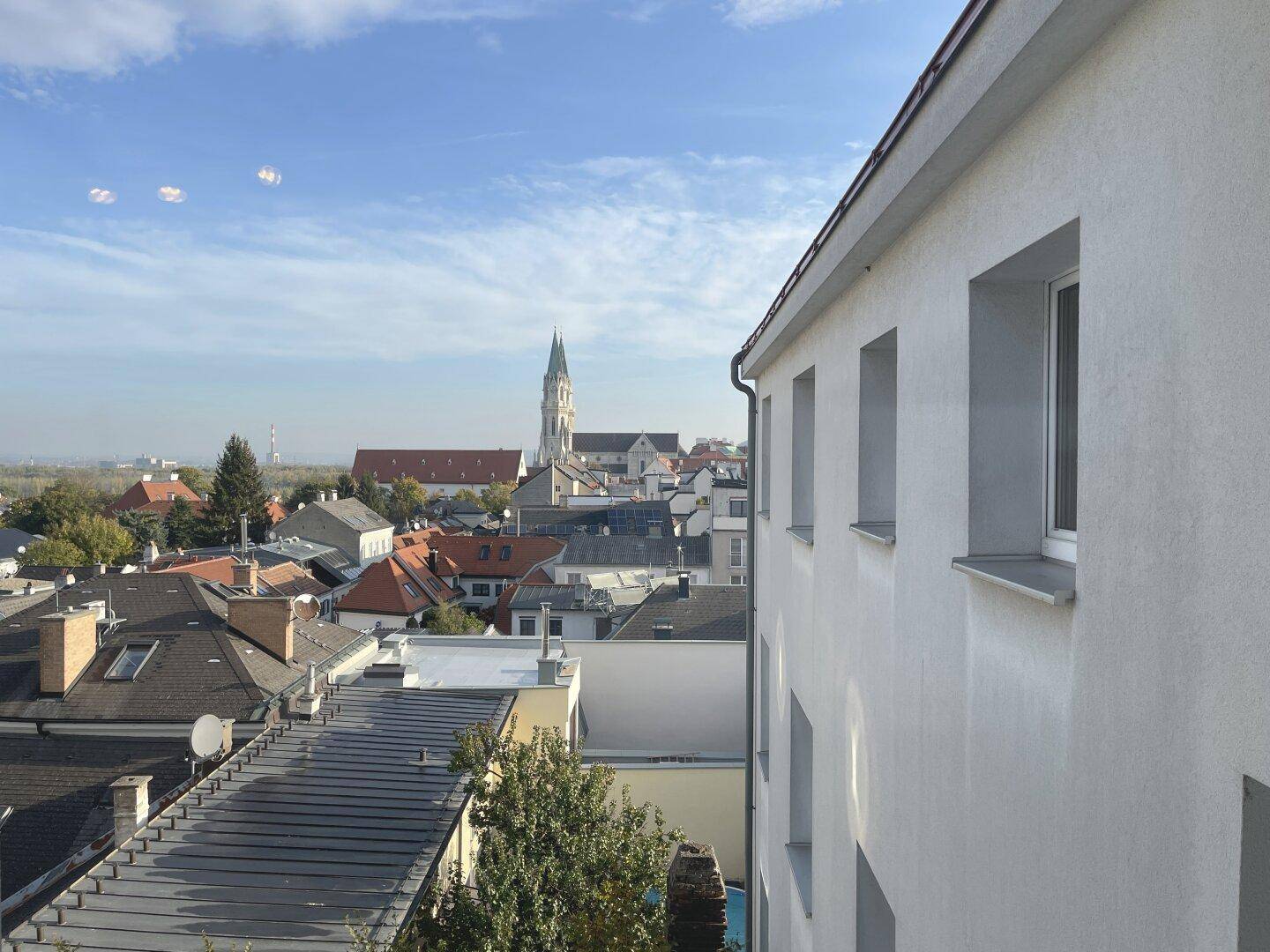Ansicht der Gebäudefassade mit Fenstern und einem weiten Blick über die Stadt.