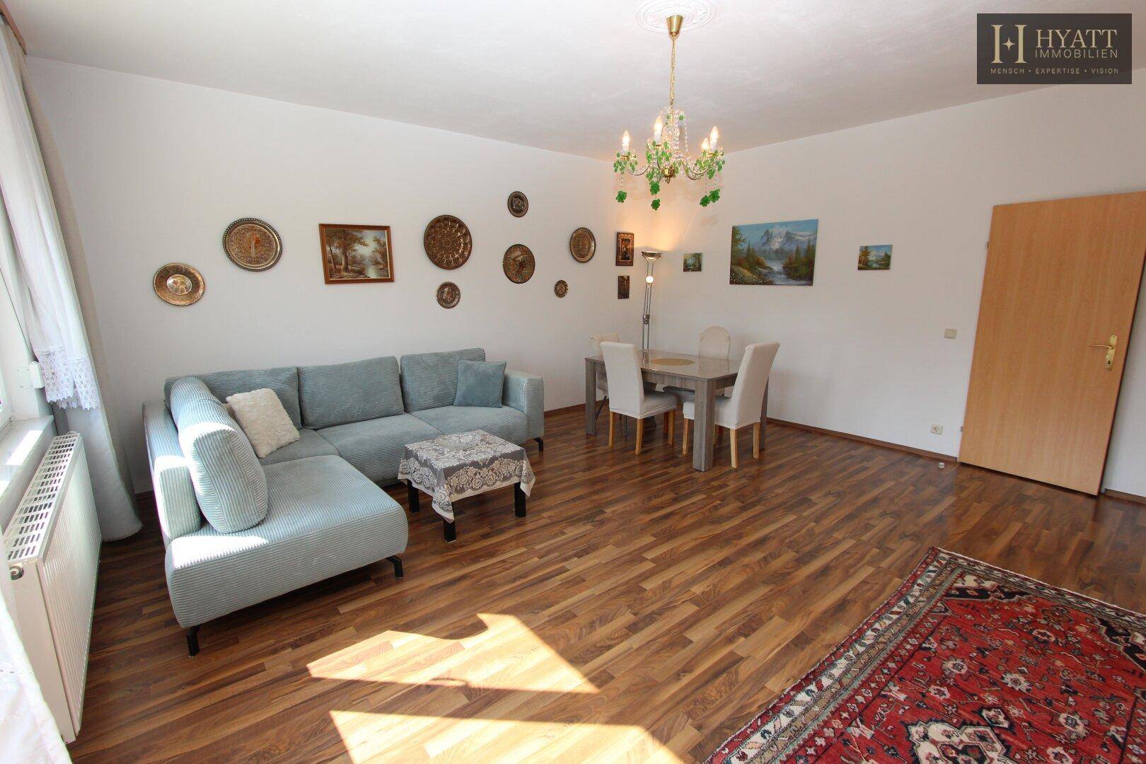 Geräumiger Wohn- und Essbereich mit Holzboden, Ecksofa und Esstisch für gesellige Stunden.