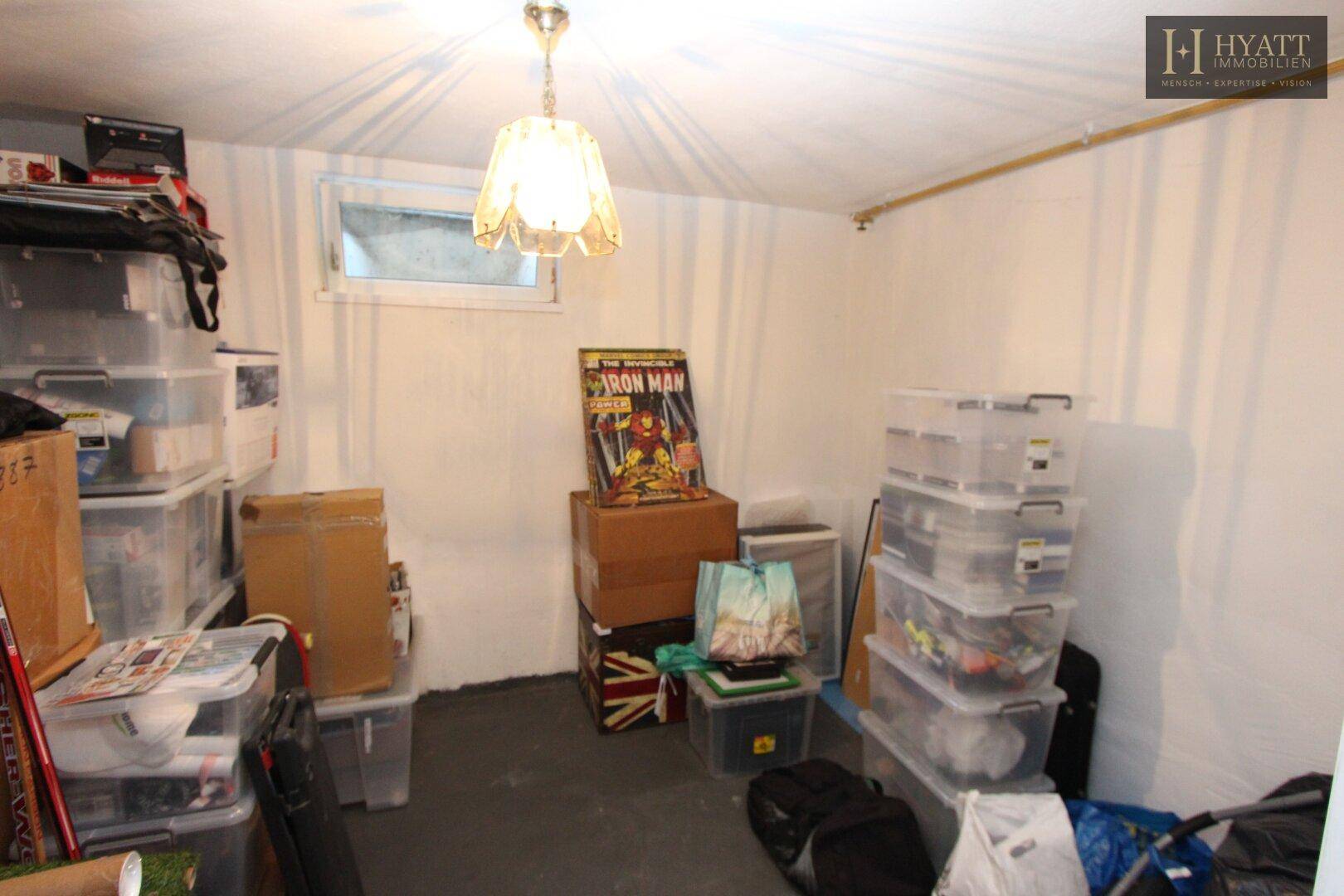 Kellerraum mit Lagerboxen und einem kleinen Fenster, ideal als Abstellfläche.