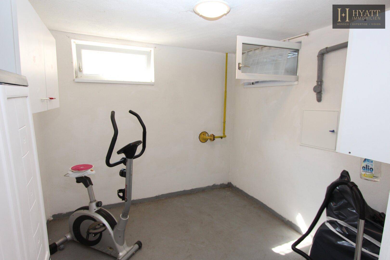 Heller Kellerraum mit Fitnessgerät und kleinem Fenster, nutzbar als Hobbyraum.