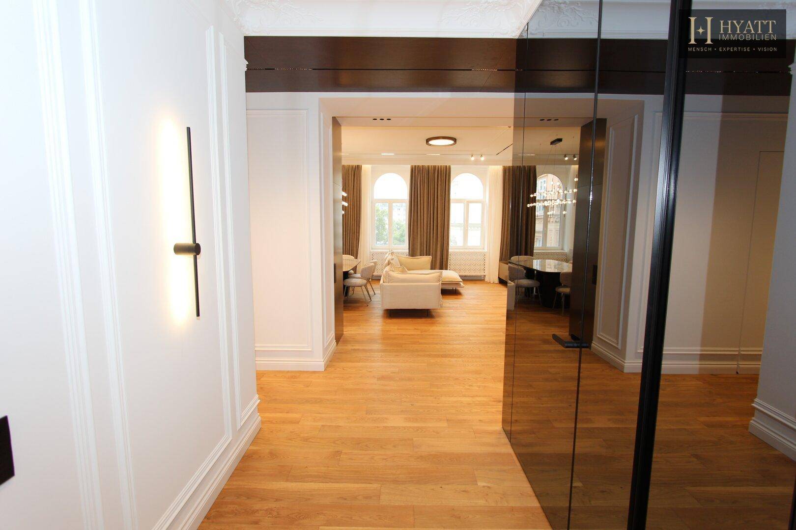 Eingangsbereich mit Holzboden und Blick in den offenen Wohn- und Essbereich.