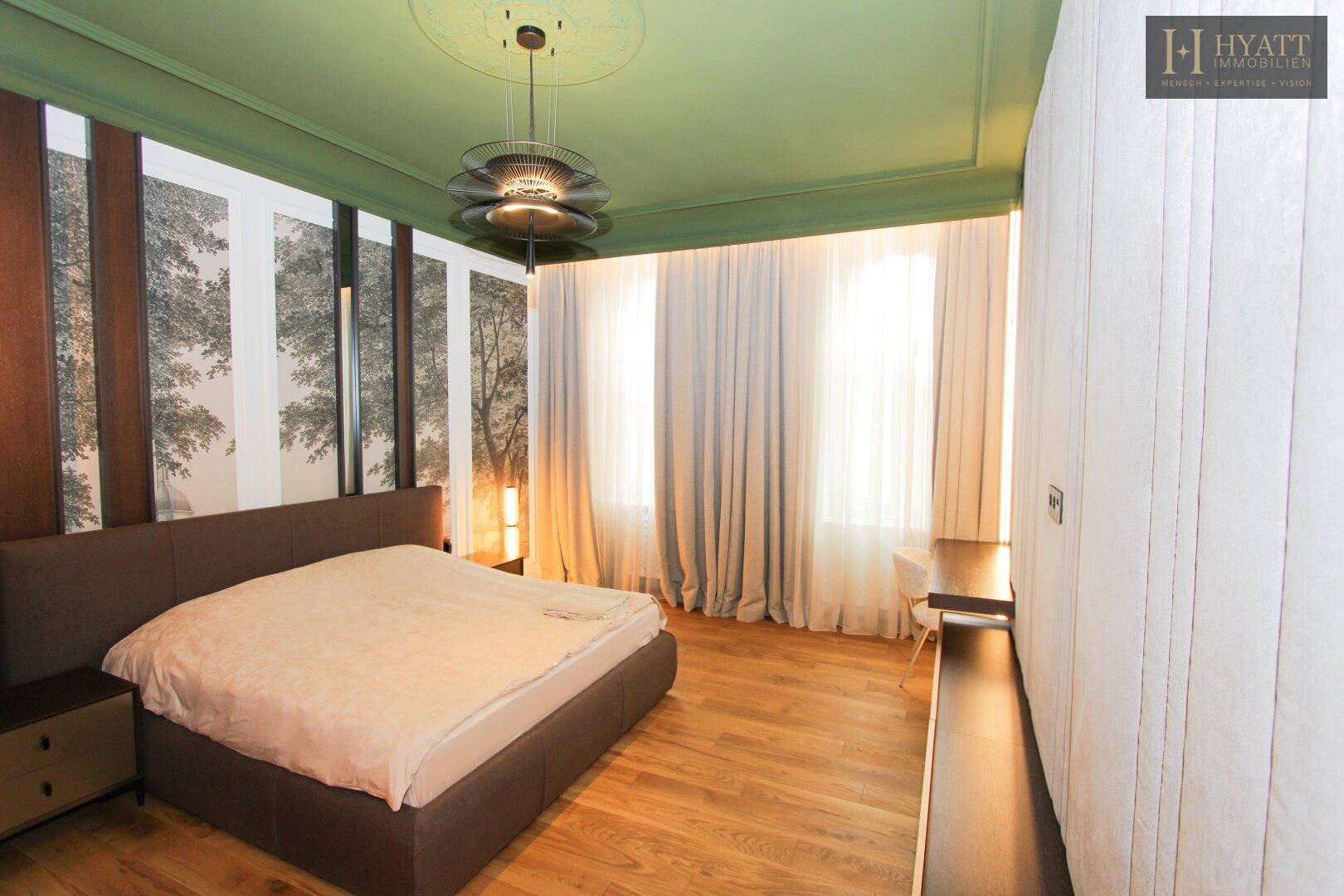 Geräumiges Schlafzimmer mit Holzboden, grüner Decke und großen Fenstern.