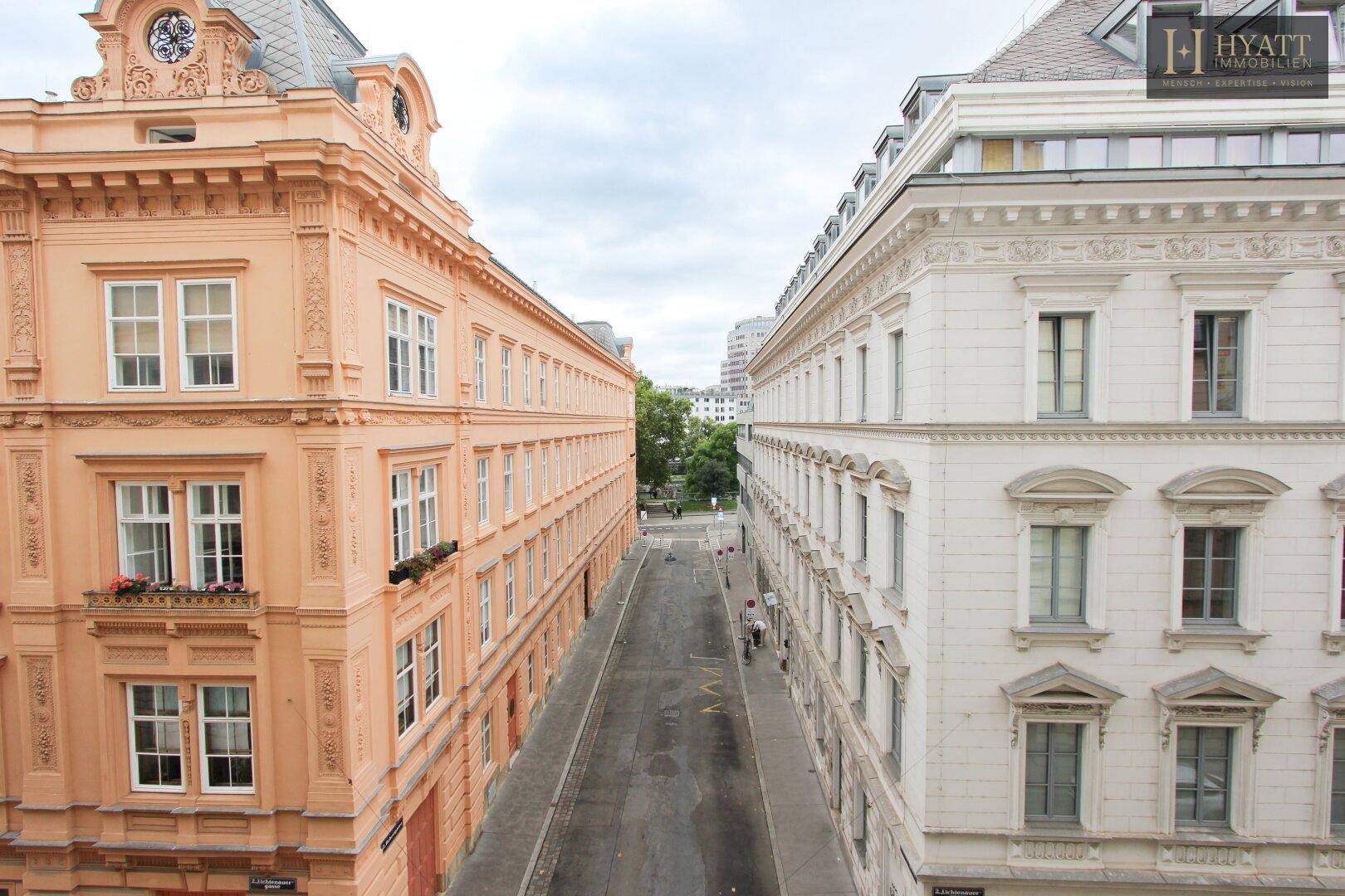 Historische Gebäude mit klassischer Architektur und Blick auf die Stadtstraße.