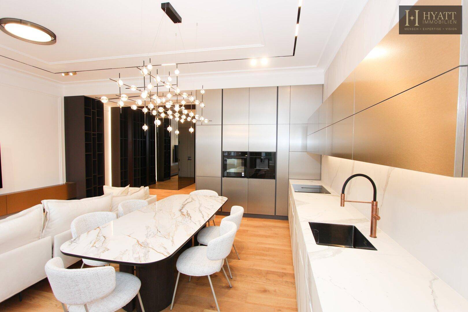 Hochwertige Einbauküche mit modernen Geräten, Marmorarbeitsplatten und integriertem Essbereich.