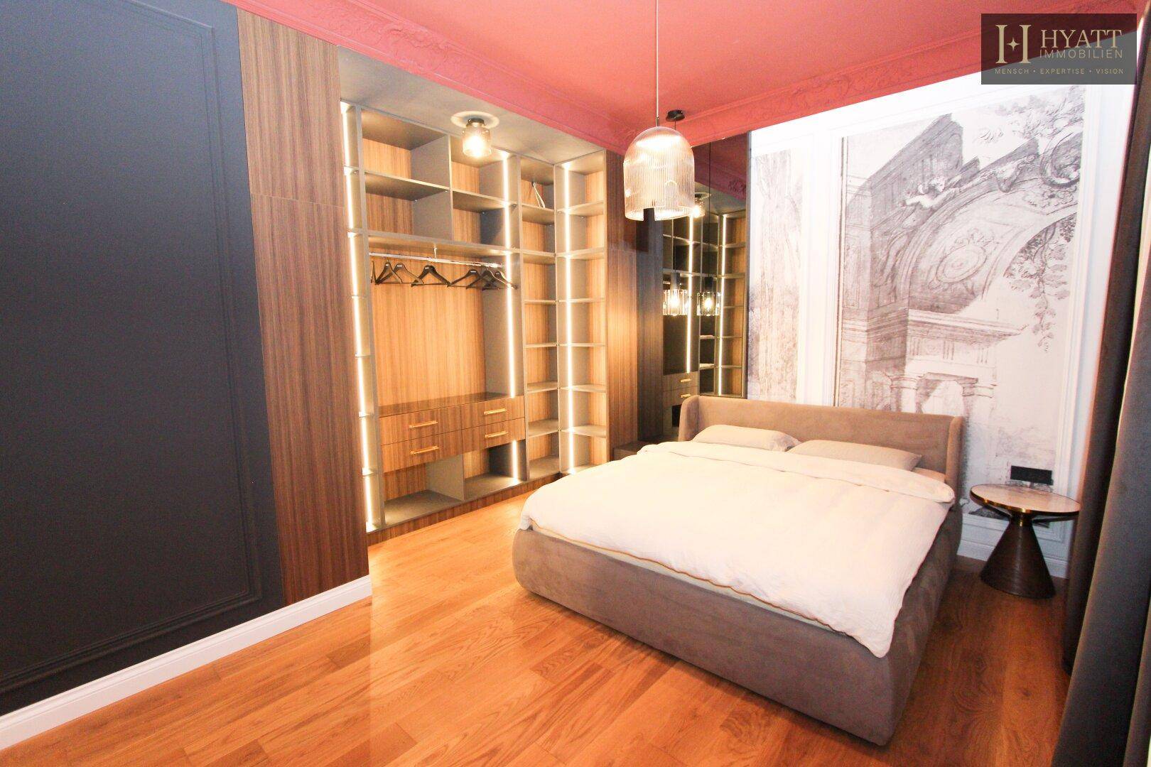 Modernes Schlafzimmer mit Holzboden, Einbauschränken und dekorativer Wandgestaltung.