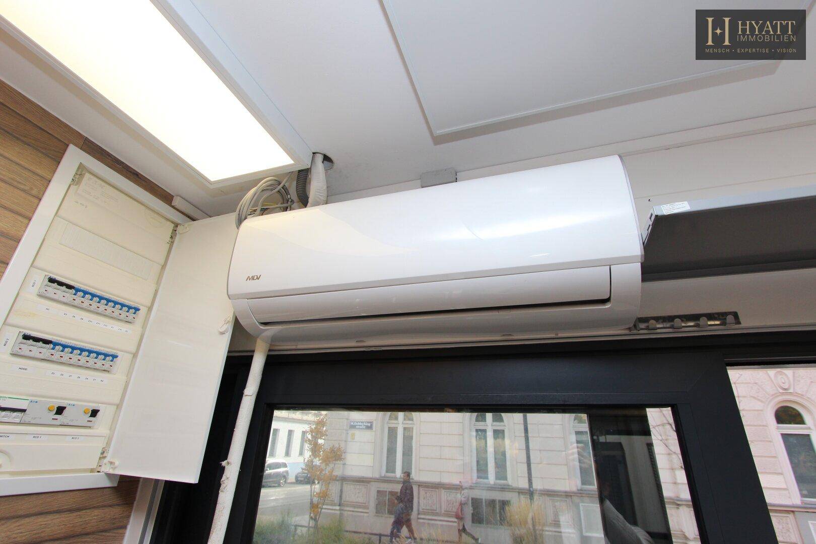 Klimaanlage und Sicherungskasten an der Wand der Kiosk-Küche, über einem Fenster.